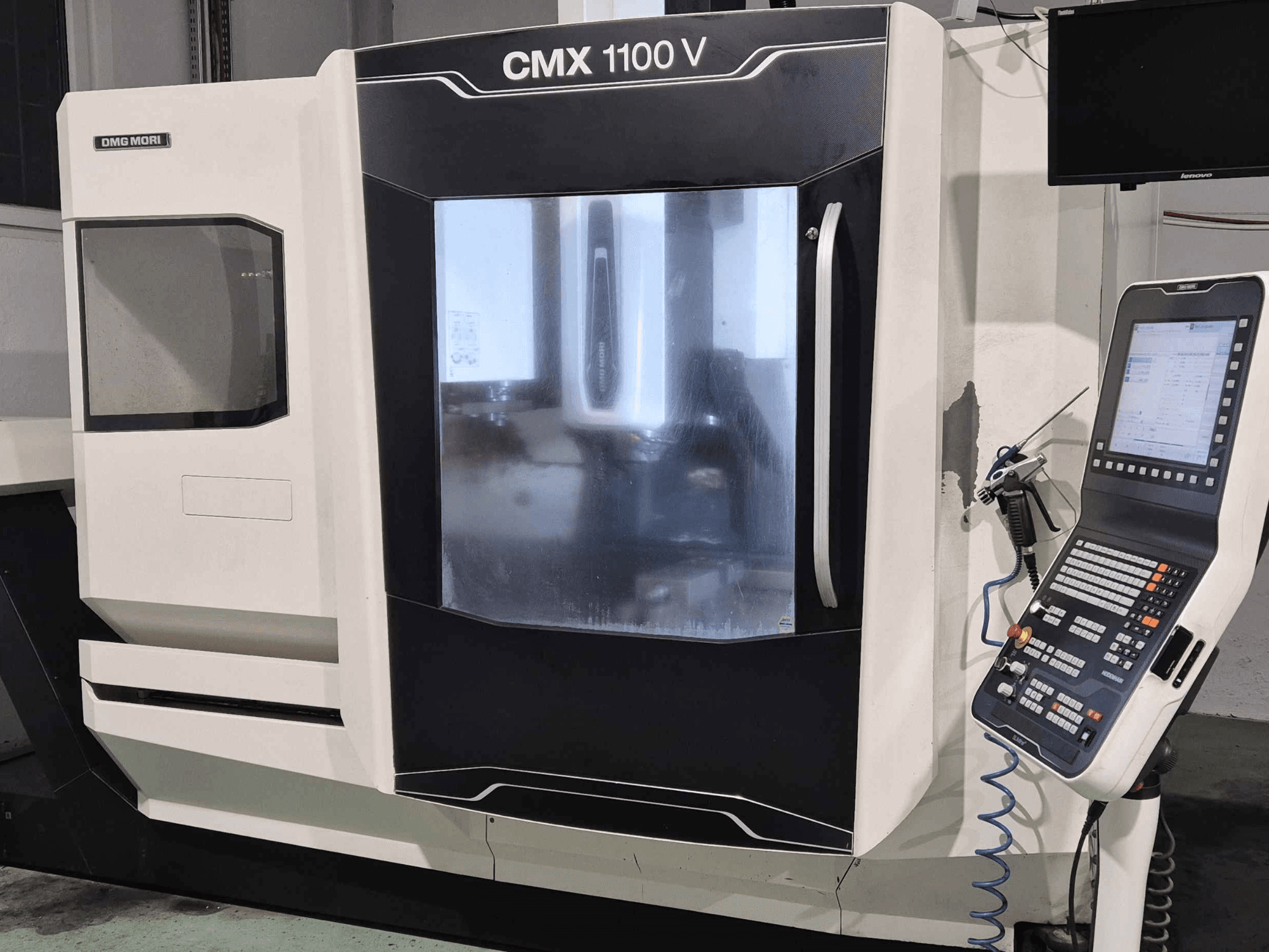 DMG Mori CMX 1100 V, CNC-koneen etukuva, jossa ohjauspaneeli, digitaalinen näyttö ja jäähdytysnesteen asetus näkyvissä.