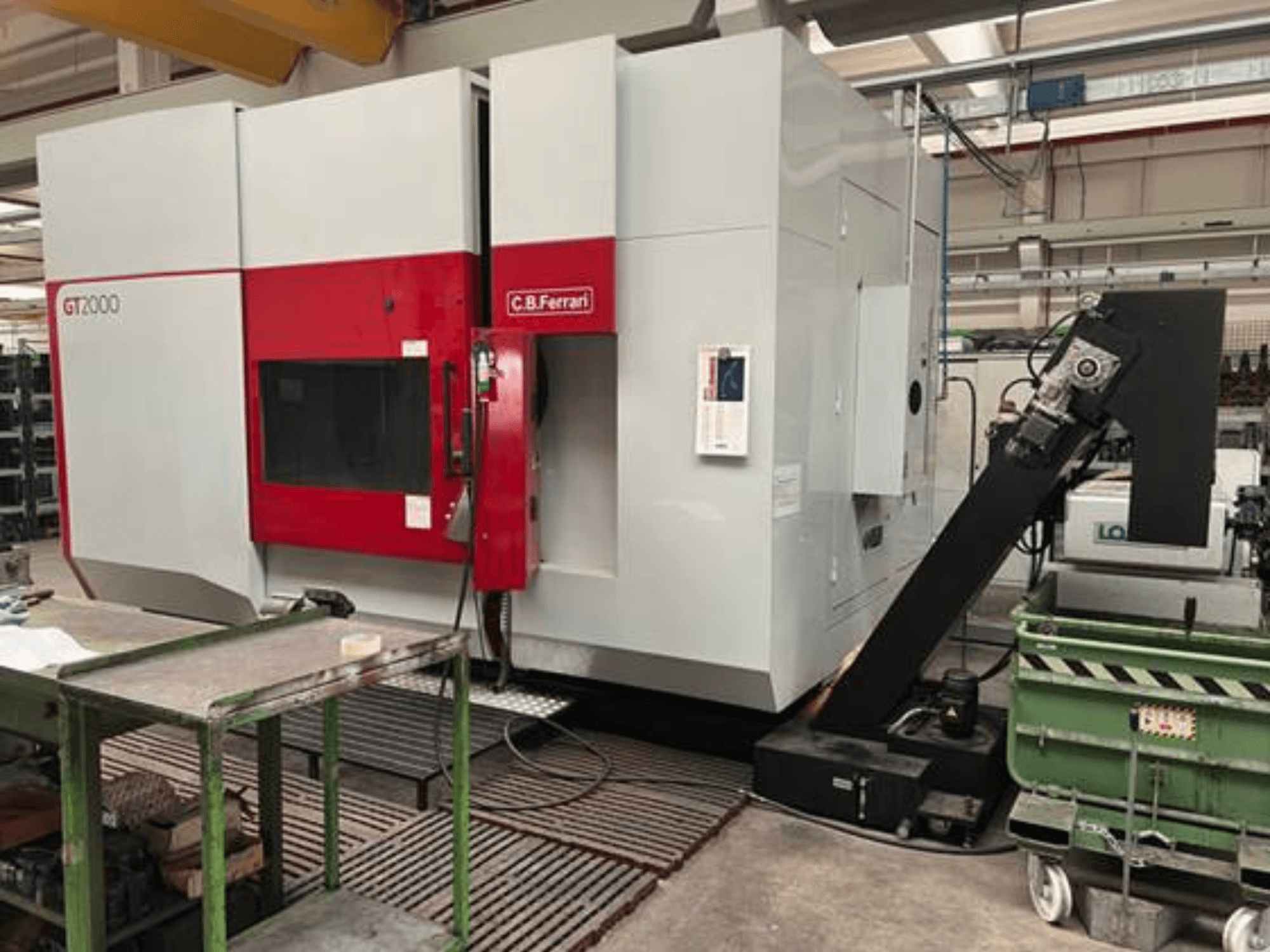 C.B. Ferrari GT2000 -jyrsinkone etukuvassa, jossa on robottivarsi ja teollinen työtila vihreällä kärryllä.