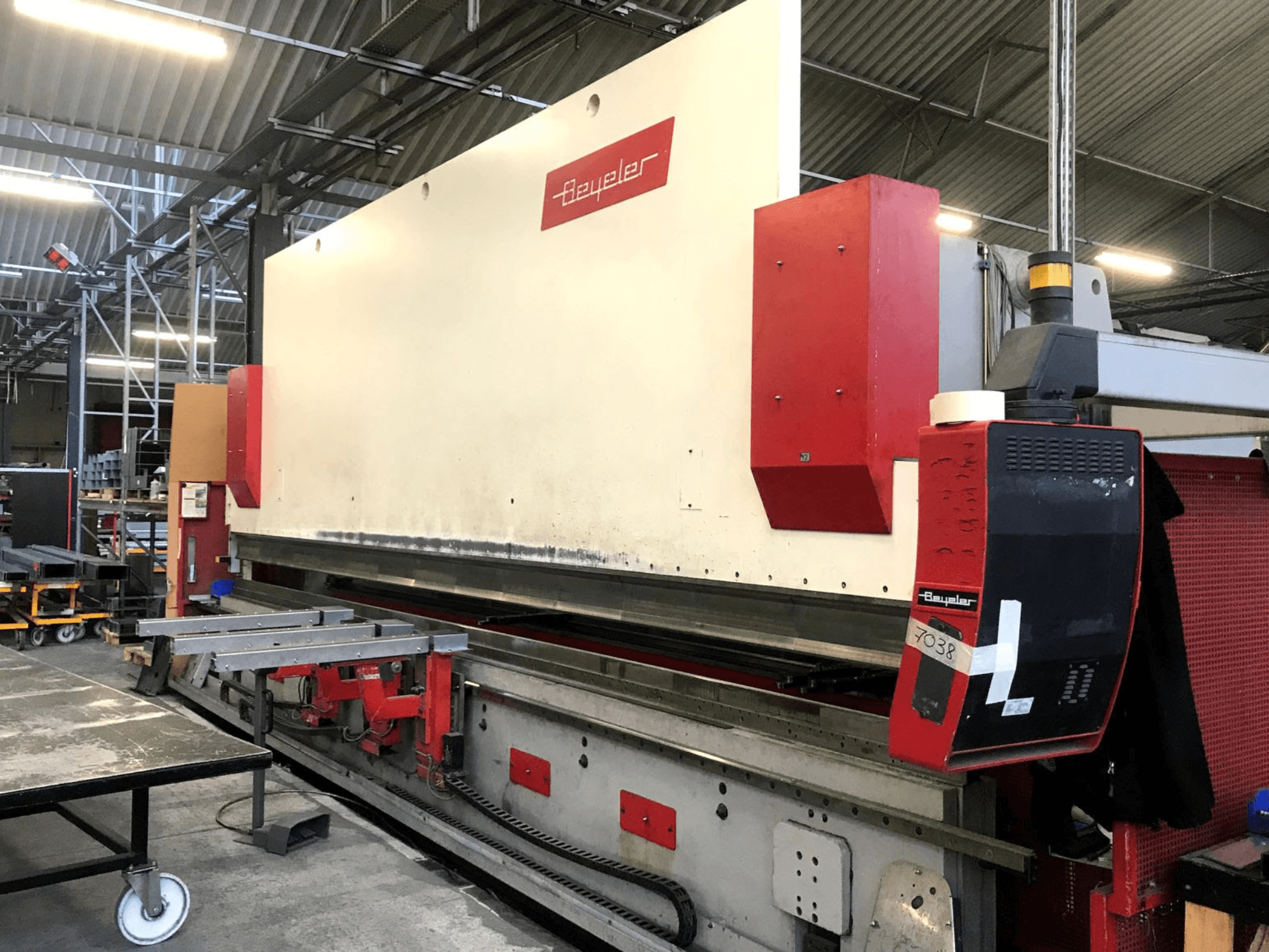 BEYELER PR-10 -taivutuspuristin, etunäkymä, jossa näkyvät ohjauspaneeli ja metallityöpöytä työpajaympäristössä.