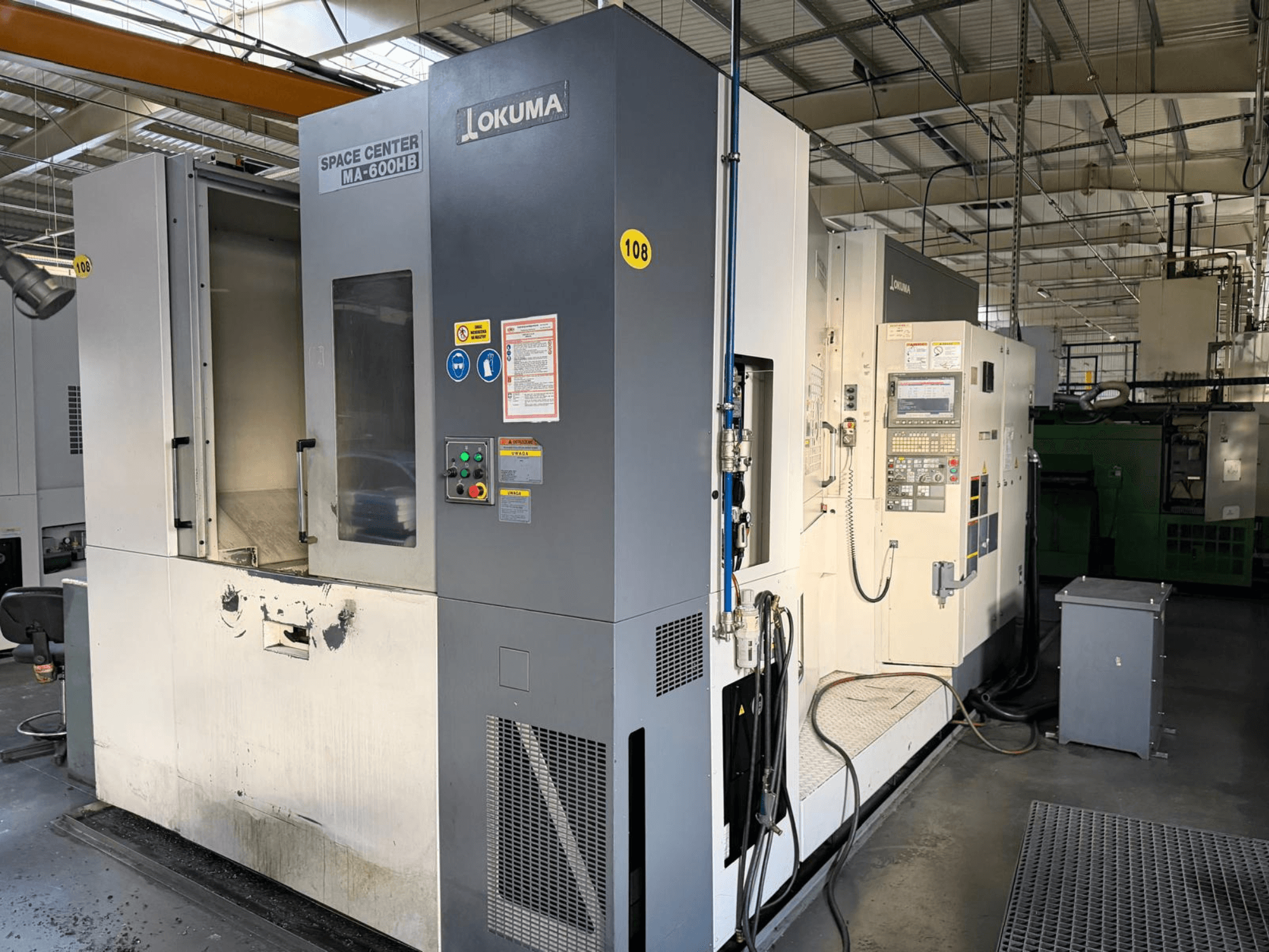 Okuma MA-600 HB -vaakakoneistuskeskus, etukuva, jossa näkyy ohjauspaneeli ja leikkausalue, jossa on näkyviä kulumisjälkiä.
