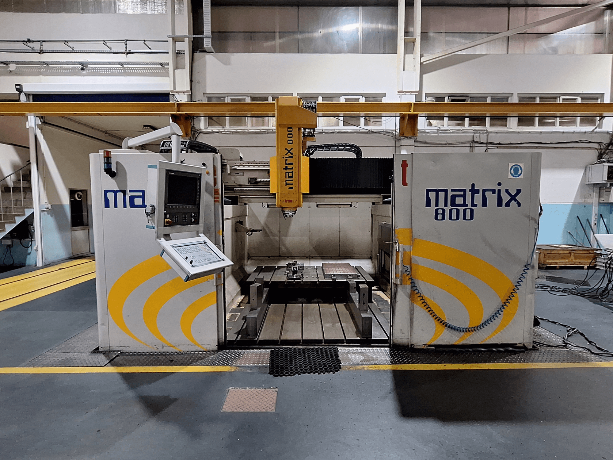 Gantry-jyrsin Breton Matrix WM 800 K25 työpajassa, jossa ohjauspaneeli ja työpöytä edestäpäin.