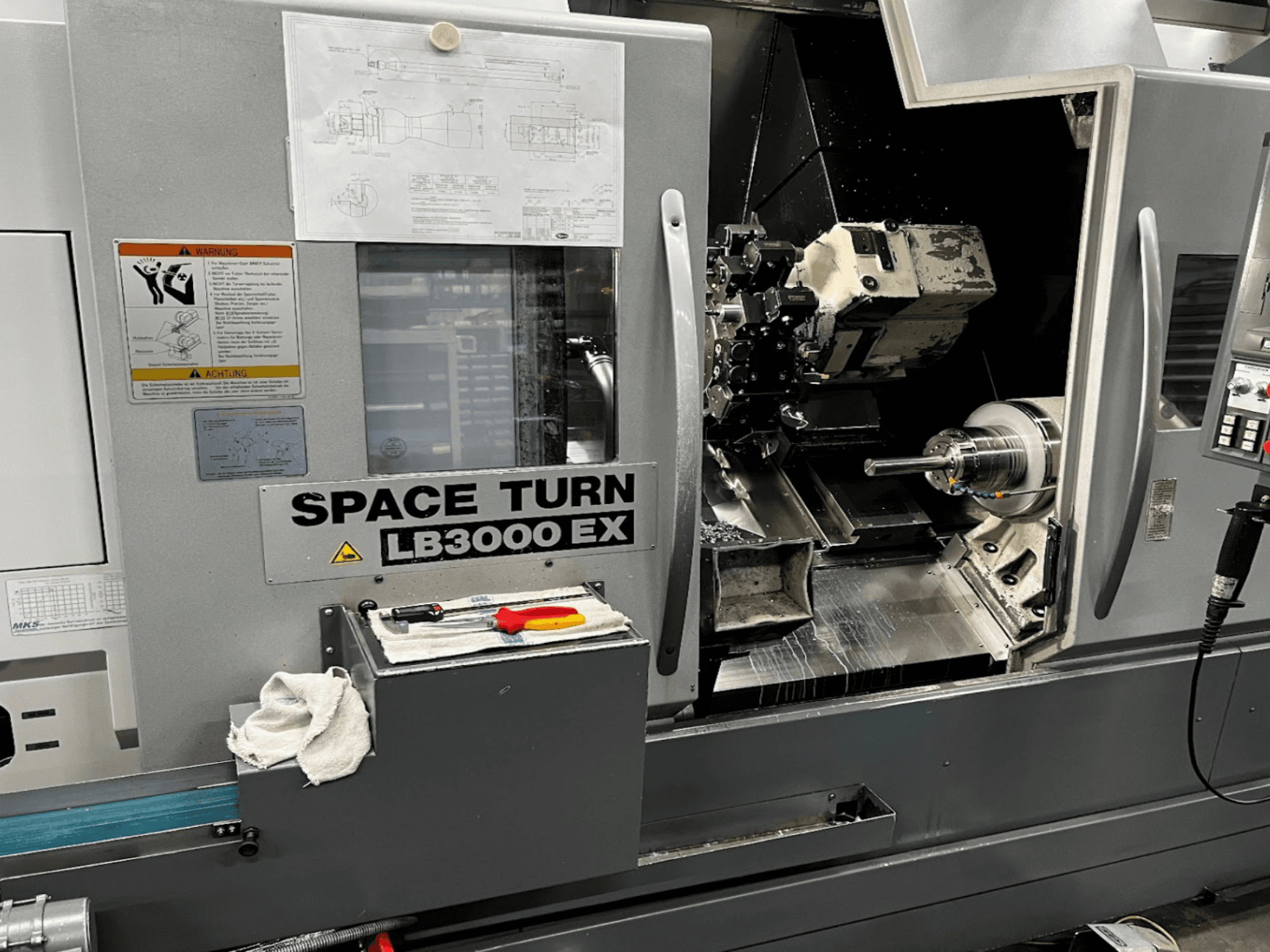 Okuma LB3000EX MYW vaakasuora sorvauskone, etukuva, jossa ohjauspaneeli, työkalut ja työtilan yksityiskohdat näkyvissä.