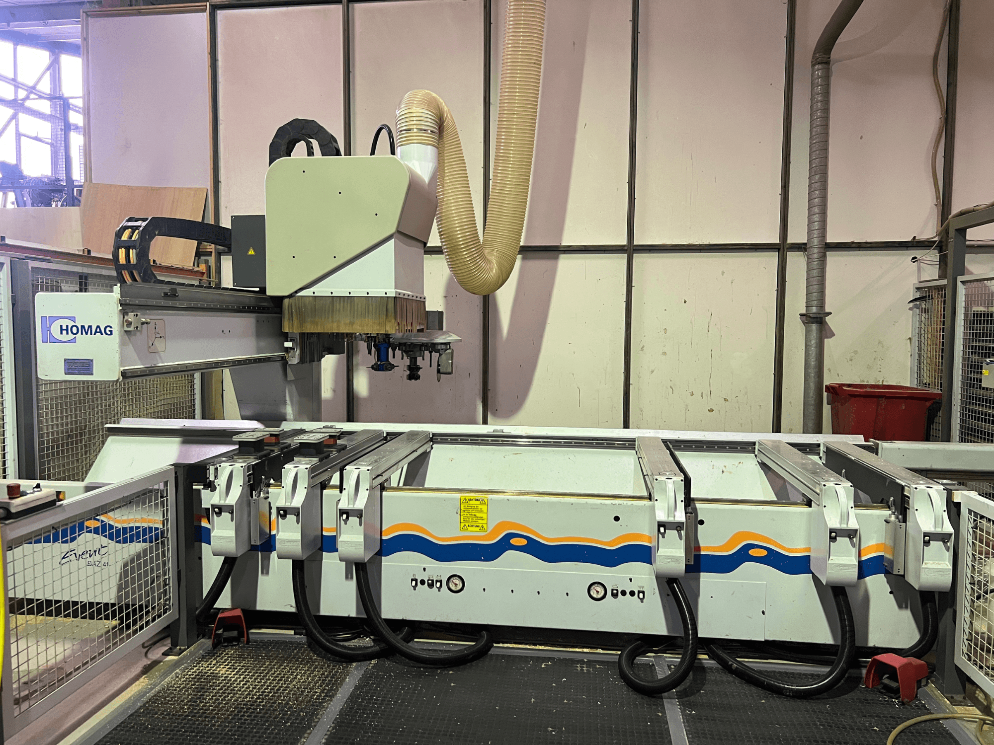 HOMAG BIZ 4 CNC-kone työpajassa; etukuva, jossa näkyy pölynpoistojärjestelmä ja ohjauspaneeli kaapeleineen.