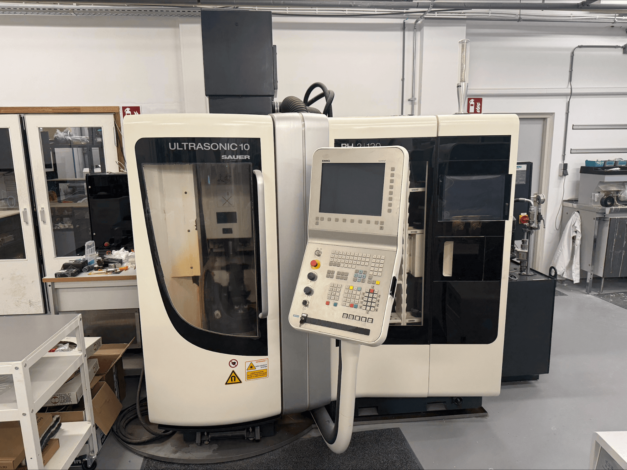 DMG Sauer Ultrasonic 10 + PH 2 | 120 vertikaalinen työstökeskus, etukuva, jossa on ohjauspaneeli ja suuri katseluikkuna.