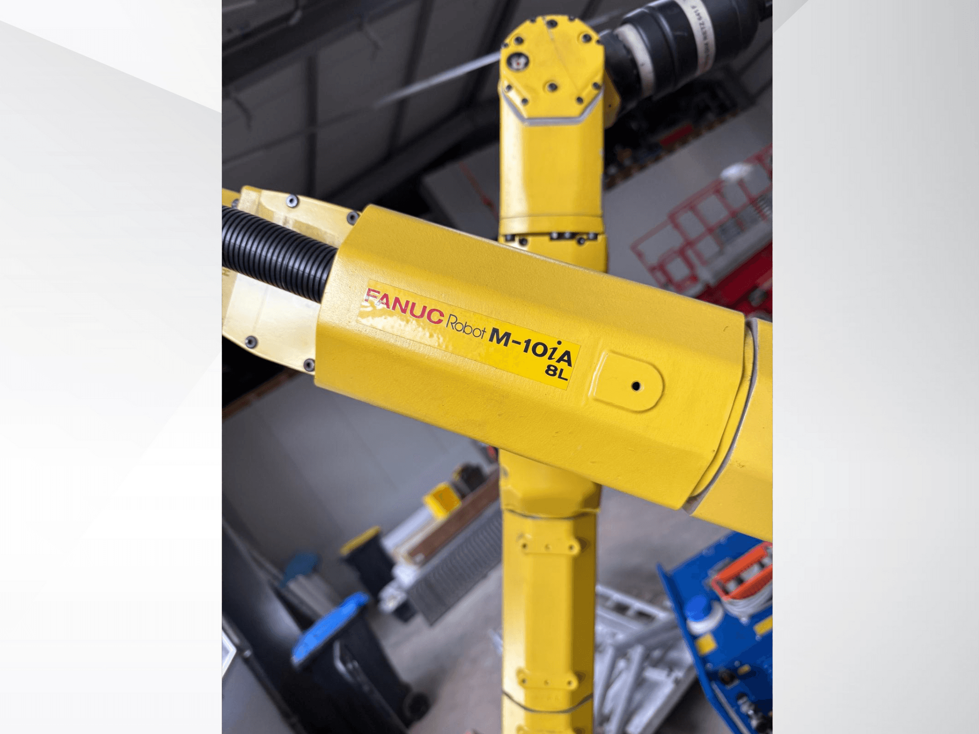Keltainen FANUC-robotti M-10iA 8L sivulta katsottuna, jossa esitellään käsinivel ja mekaaniset komponentit teollisuusympäristössä.