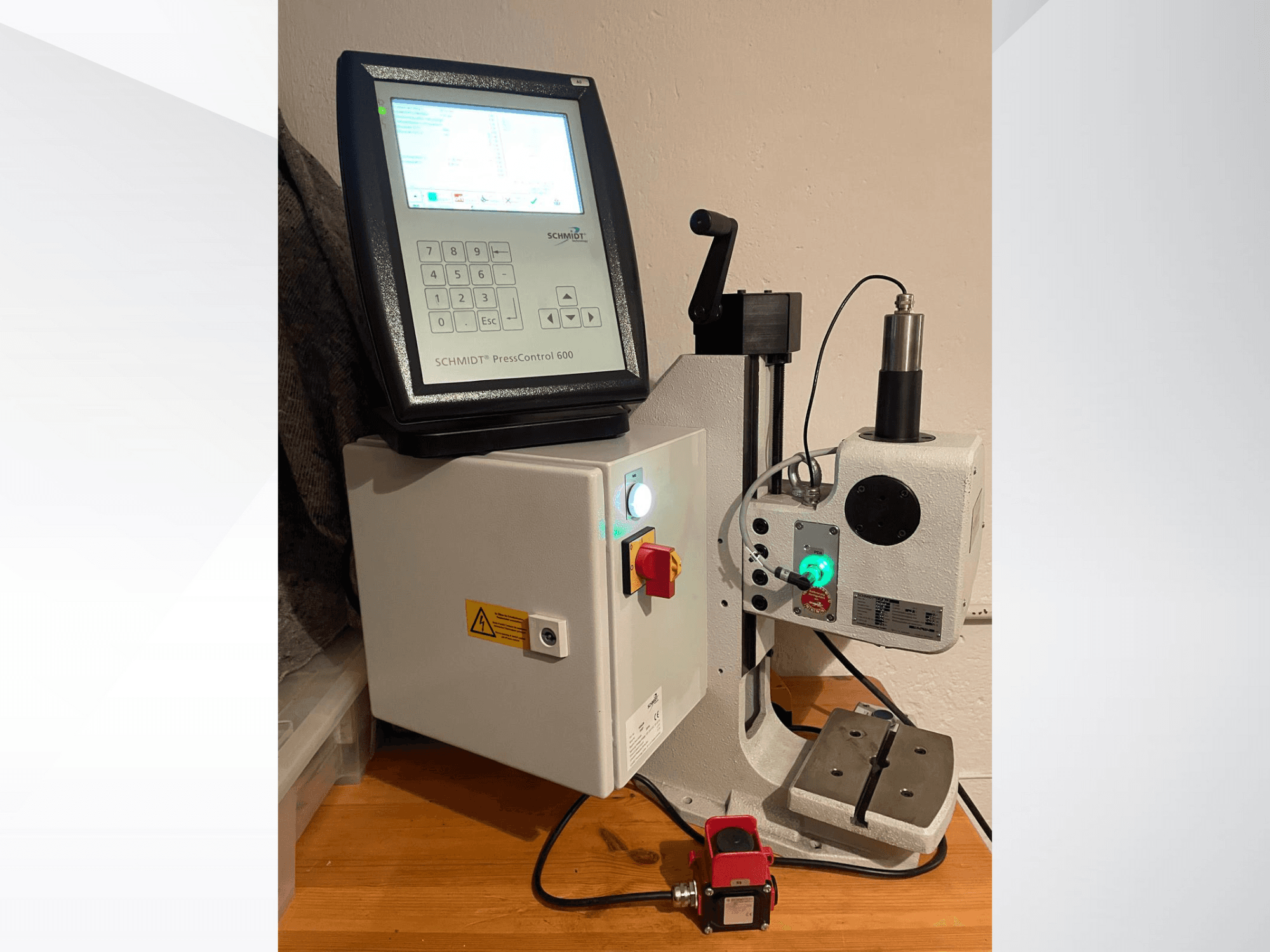 SCHMIDT® PressControl 600, etukuva, jossa näkyy ohjauspaneeli, virtapainike ja hydraulinen puristin, jossa on turvaominaisuuksia.