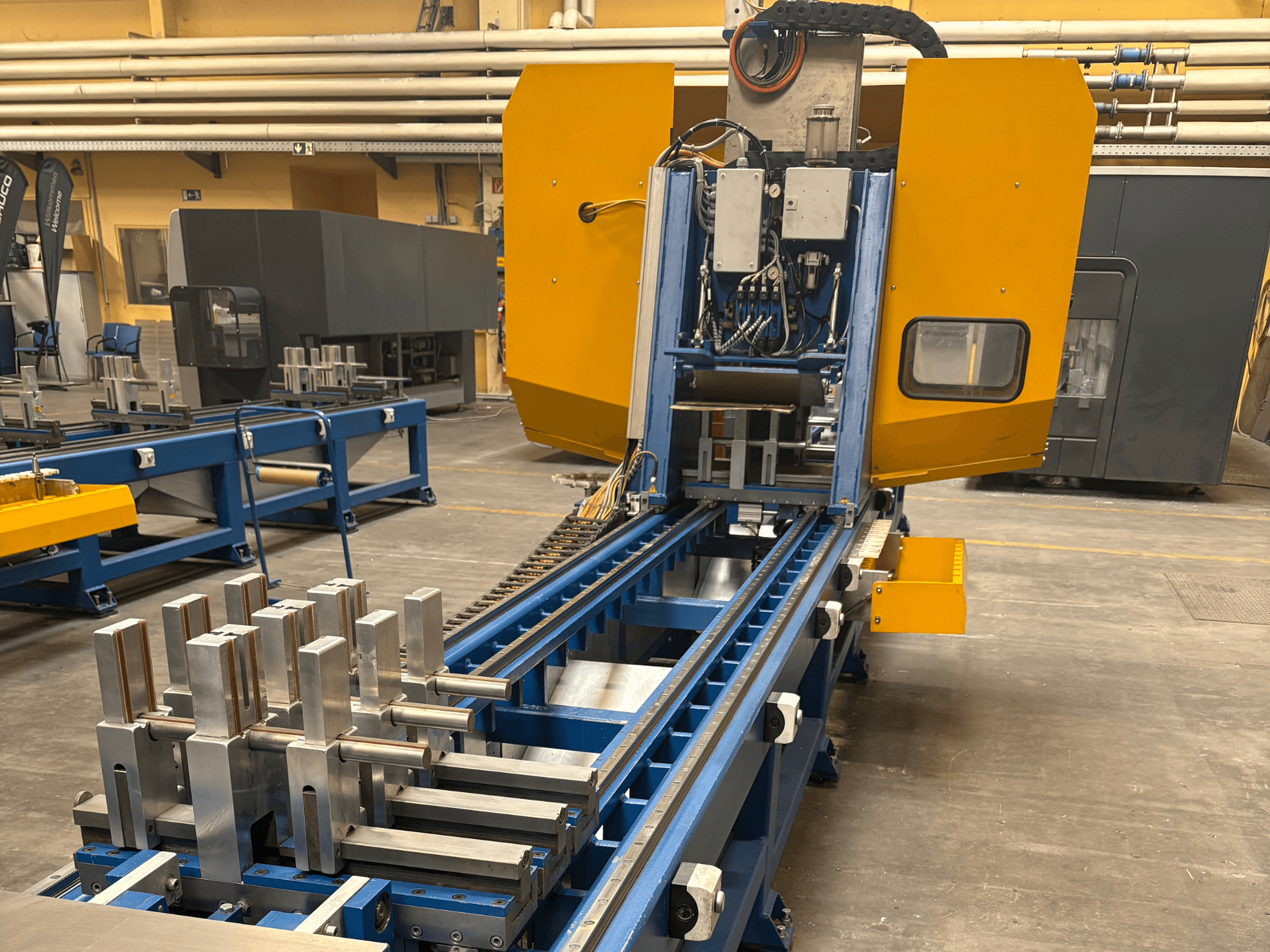 SCHÜCO PBX AL -yleiskoneistuskeskuksen etukuva, jossa metalliset työkappaleet ovat esillä sinisellä työstöalustalla.