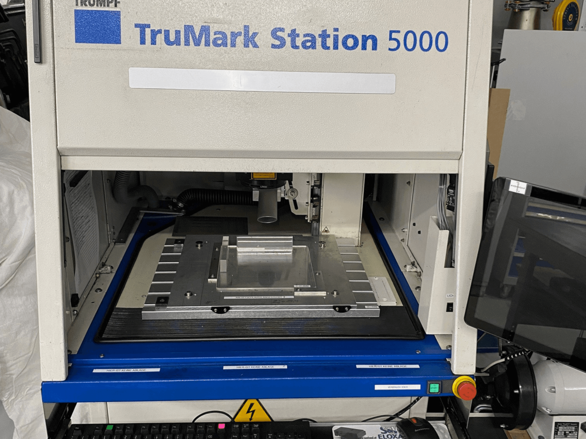 TruMark Station 5000 -lasermerkintäkoneen etukuva, jossa näkyy työpöytä, hallintalaitteet ja valvontanäyttö.