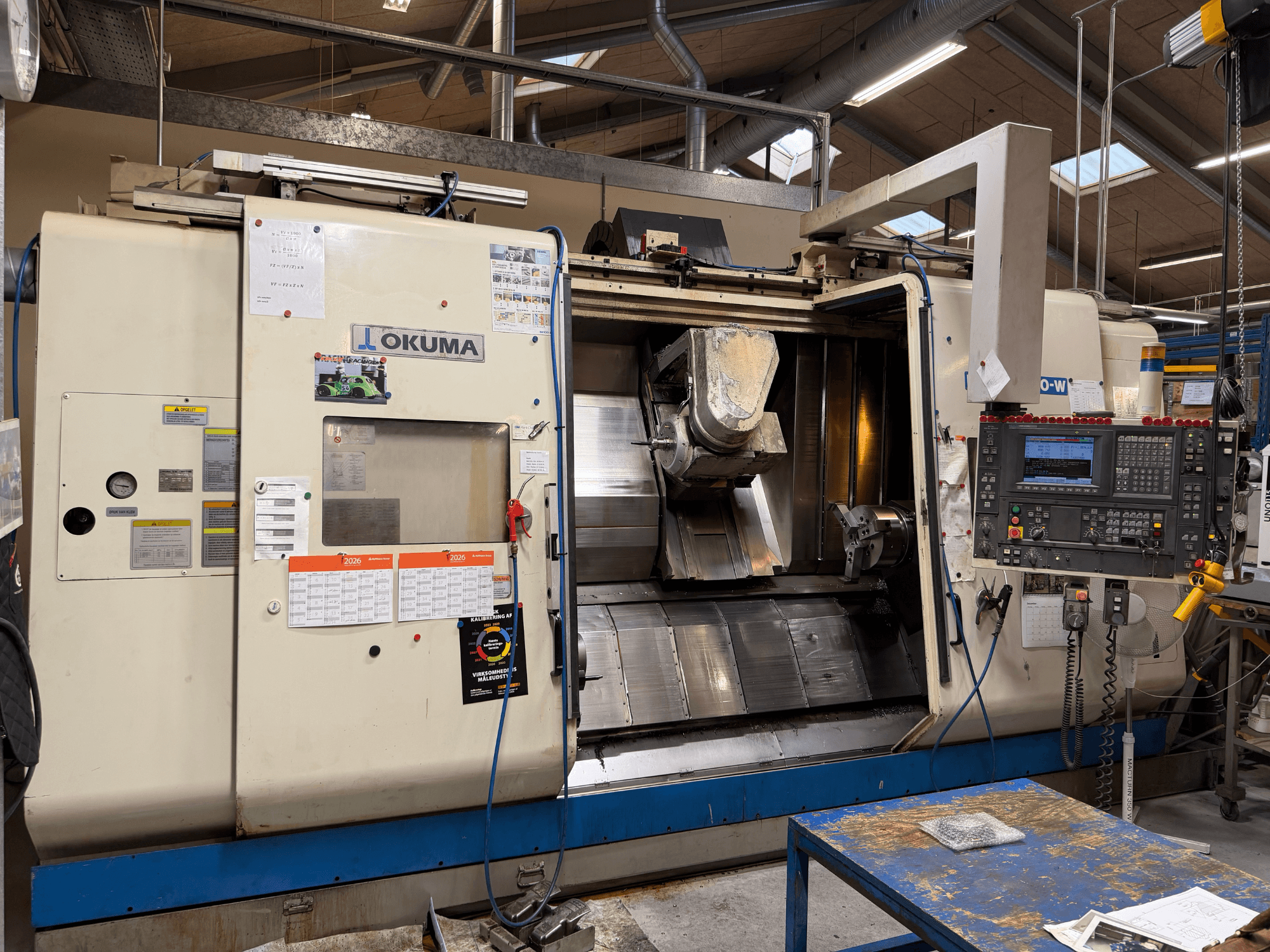 Okuma MacTurn350-W -sorvaus-jyrsinkeskus, etunäkymä, jossa näkyy ohjauspaneeli ja esteetön pääsy työstöalueelle.