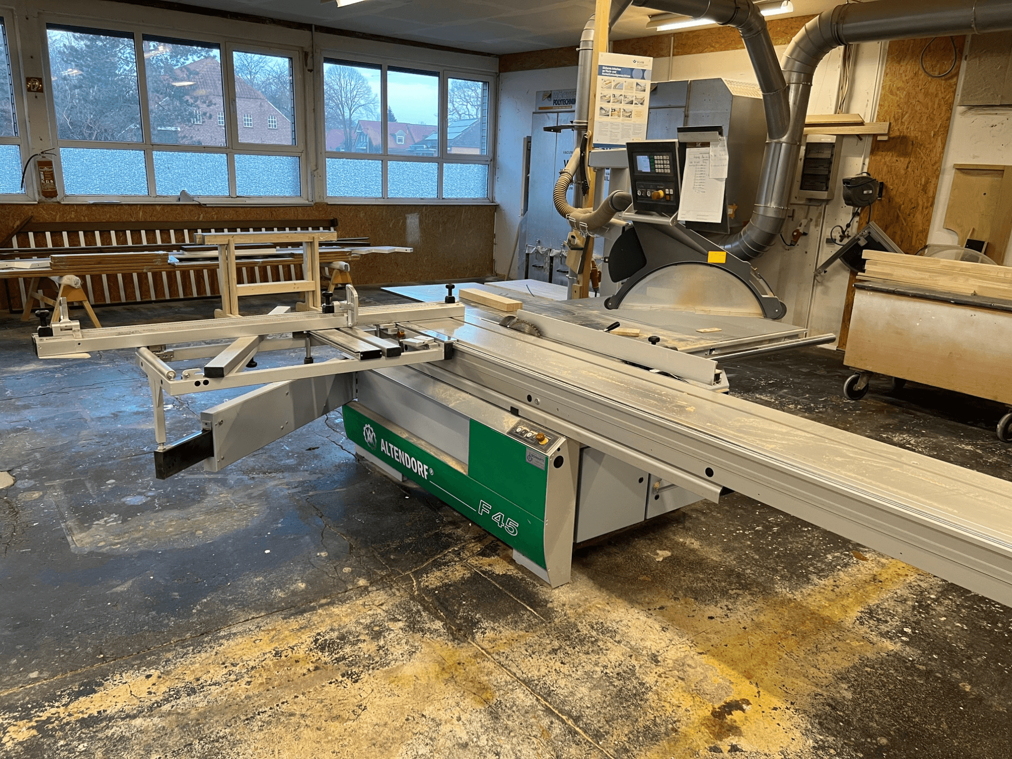Altendorf F45 -pöytäsaha työpajassa, etukuva, jossa näkyy säädettävä varsi ja ohjauspaneeli, ihanteellinen tarkkuusleikkaustehtäviin.