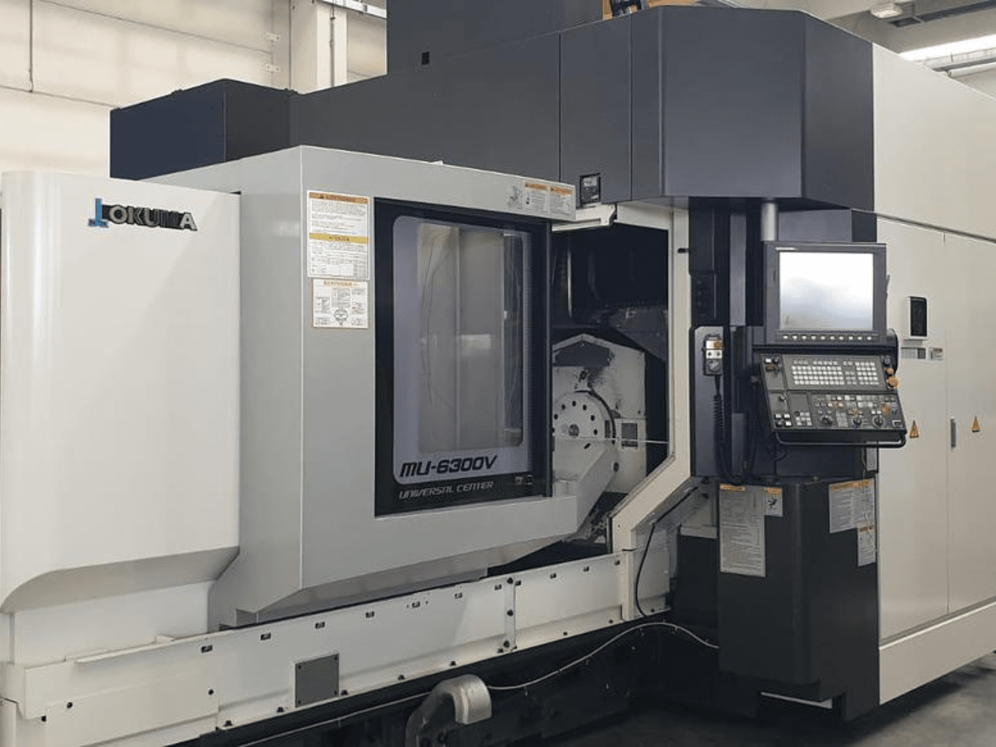 Okuma MU 6300 V -pystytyöstökeskus, etukuva, jossa näkyy ohjauspaneeli ja työstöalueen yksityiskohdat.