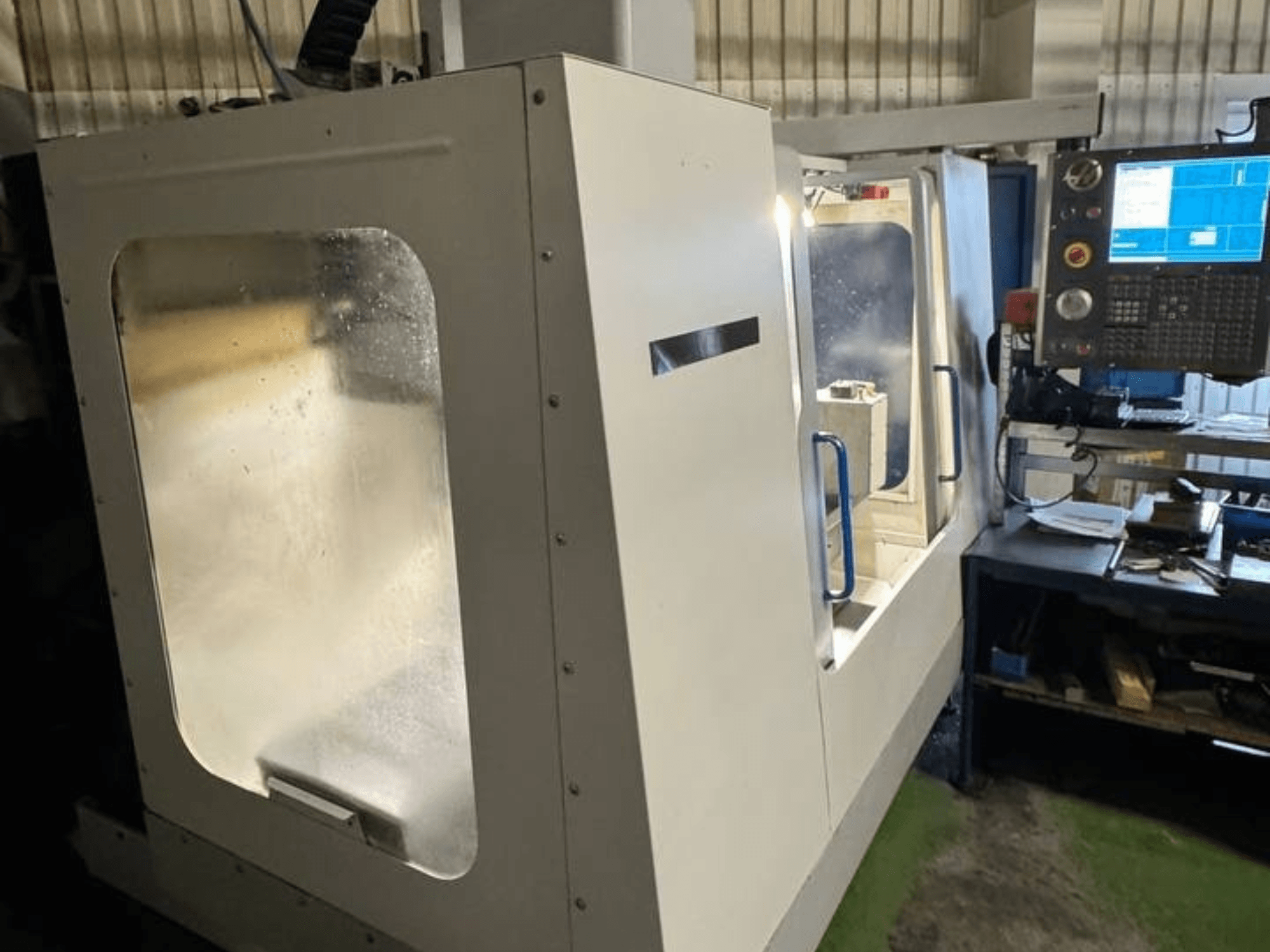 HAAS VCE 750 -pystytyöstökeskus sivukuvassa, jossa on ohjauspaneeli ja selkeä suojakotelo.