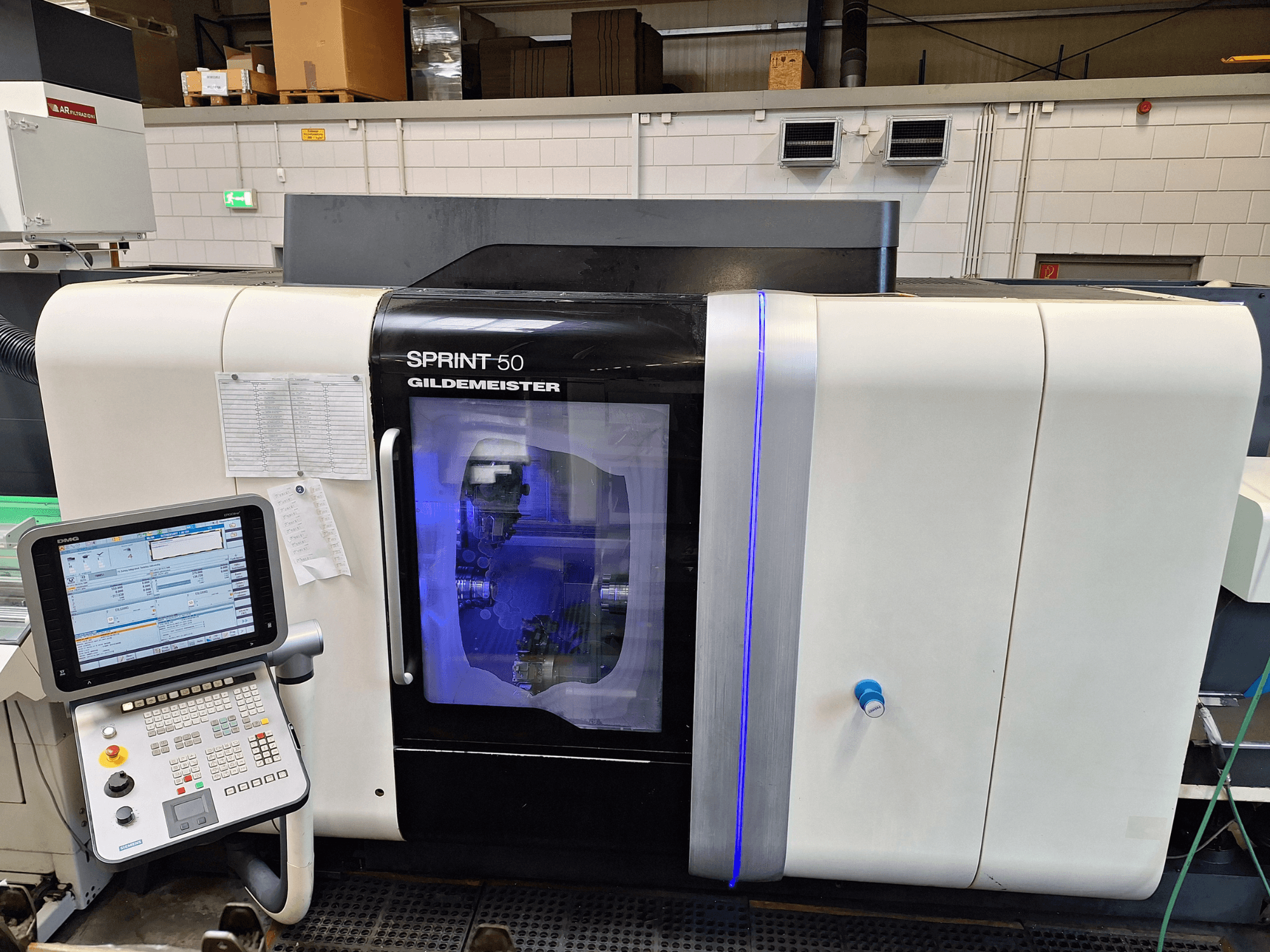 DMG Sprint 50 2T vaakasuuntainen sorvauskone, etukuva, jossa on ohjauspaneeli ja läpinäkyvä kotelo, jossa koneet näkyvät sisältä.