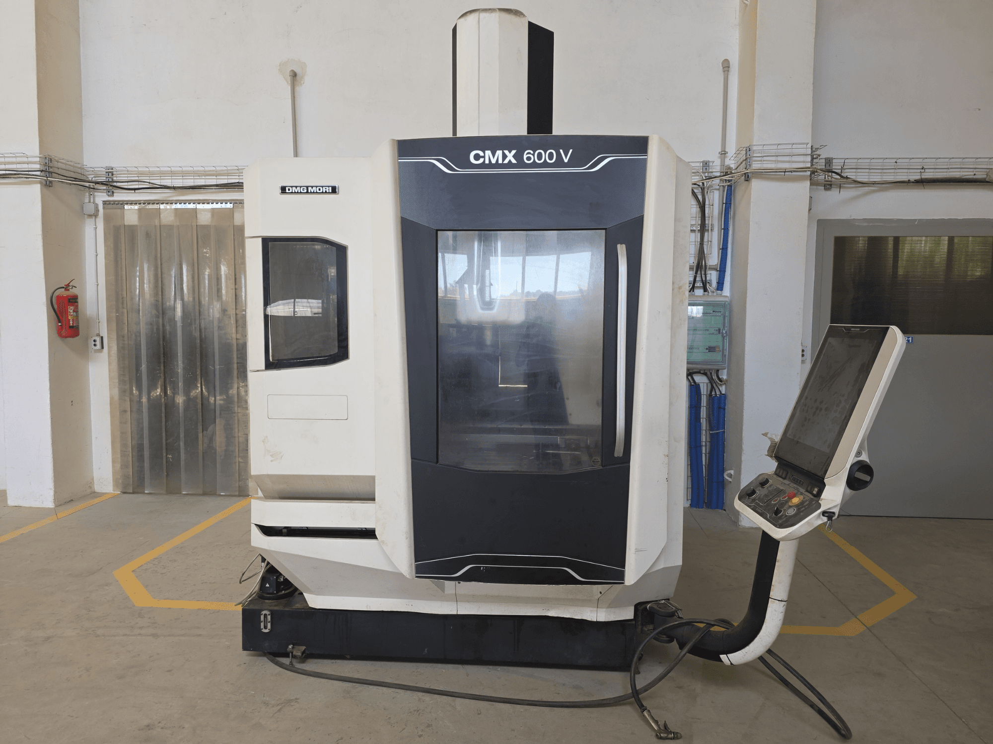 DMG MORI CMX 600 V -pystytyöstökeskus, etukuva, jossa on ohjauspaneeli ja suuri läpinäkyvä ikkuna.
