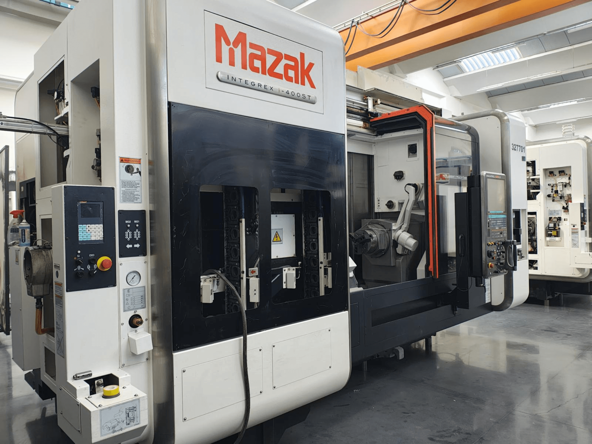 Mazak Integrex 400ST, etukuva; CNC-kone, jossa on ohjauspaneeli, karat ja robottivarsi näkyvissä työpajassa.