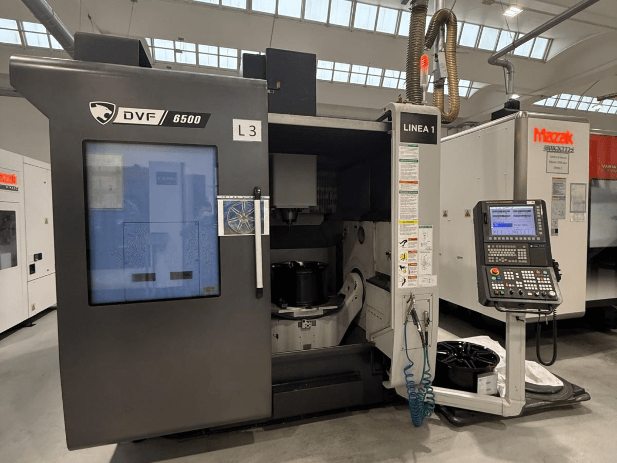 DVF 6500 CNC-kone, etukuva, jossa näkyy ohjauspaneeli ja sisätila, jossa on kappaleen kiinnityslaite.
