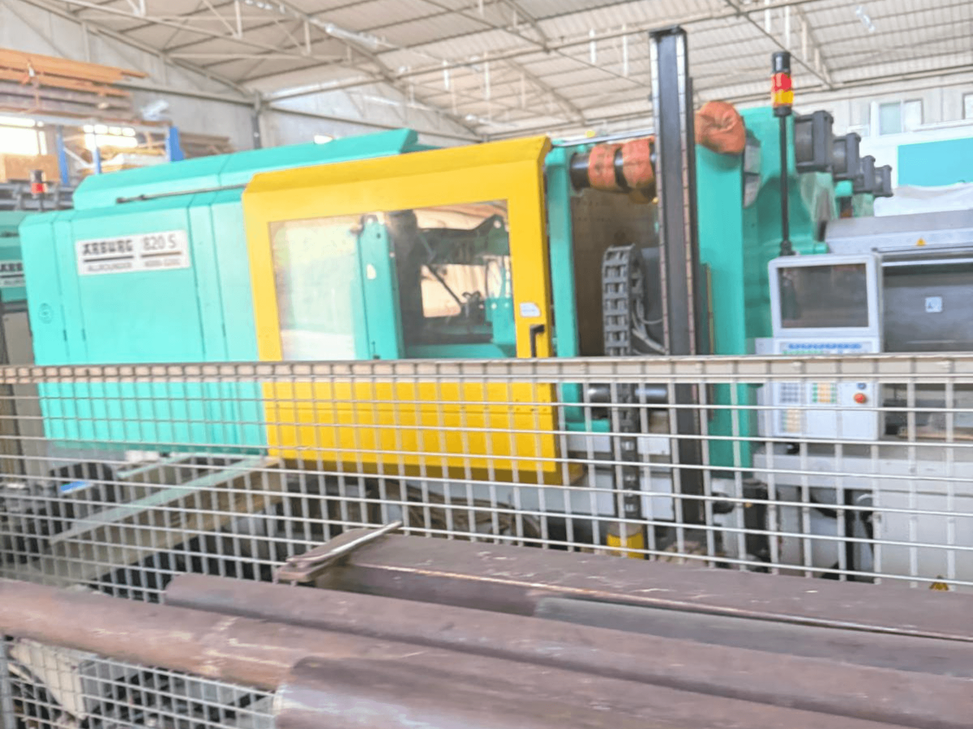 Hydraulinen ruiskuvalukone Arburg SELECTA 820 S 4000-3200, sivukuva, jossa näkyy ohjauspaneeli ja elinvoimainen keltainen ja tiilenpunainen muotoilu.