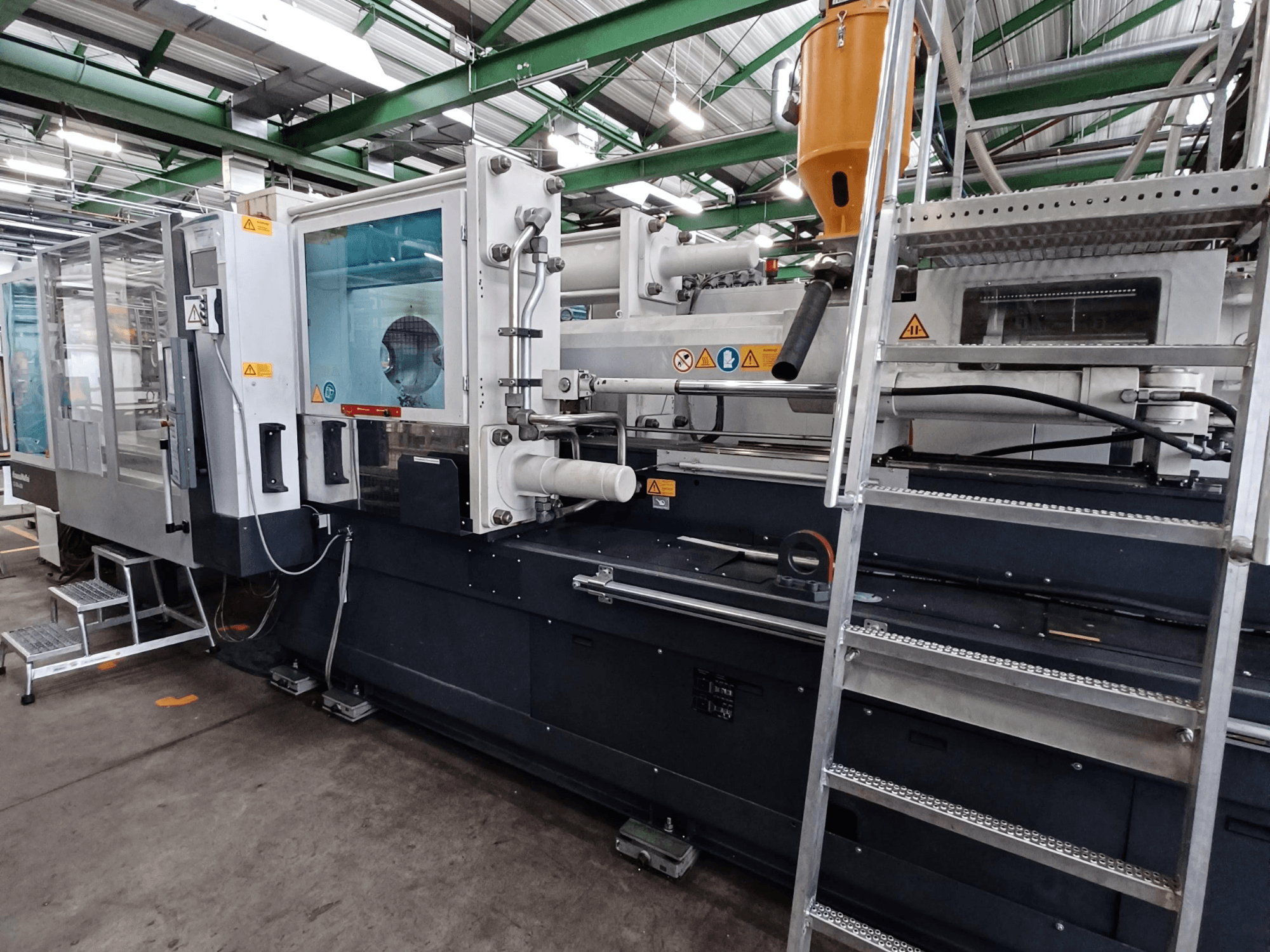 Teollinen ruiskuvalukone, jossa on selkeä etukuva, jossa näkyvät tuotemerkinnät, ohjauspaneeli ja materiaalisäiliö.