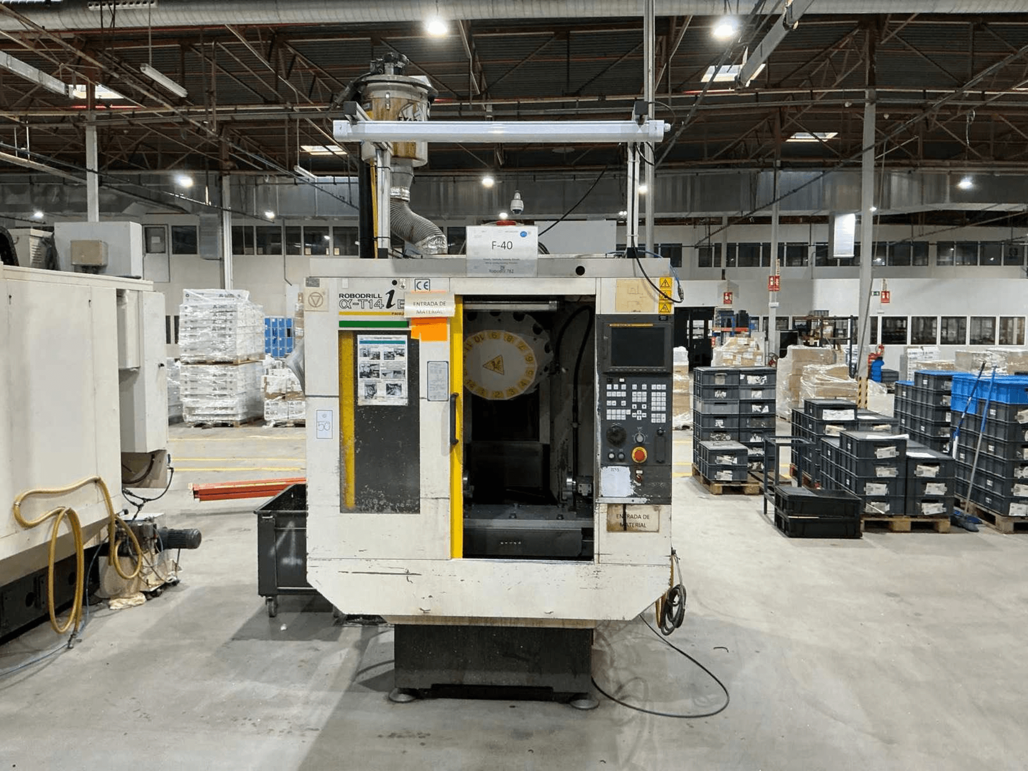 FANUC ROBODRILL α-T14iB -pystytyöstökeskus tehtaalla, etukuva, jossa näkyy ohjauspaneeli ja työkalunpidin.