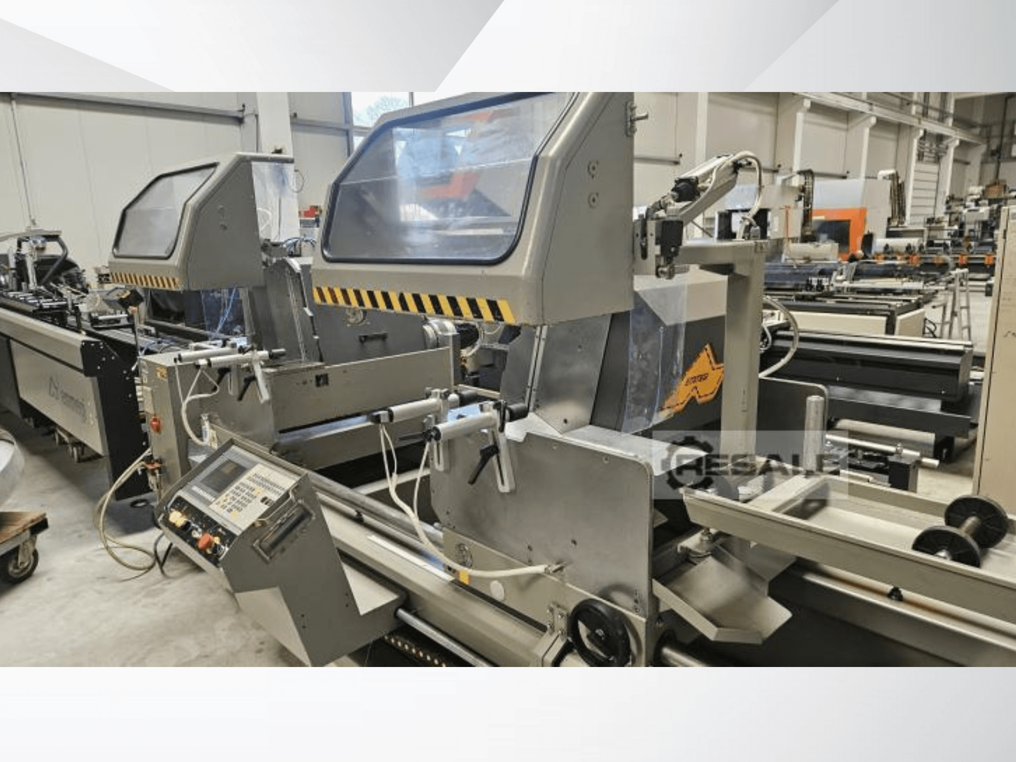 Kaksoissahauskoneet tehdasympäristössä; etukuva, jossa näkyy ohjauspaneeli, lasikannet ja leikkuuosat.