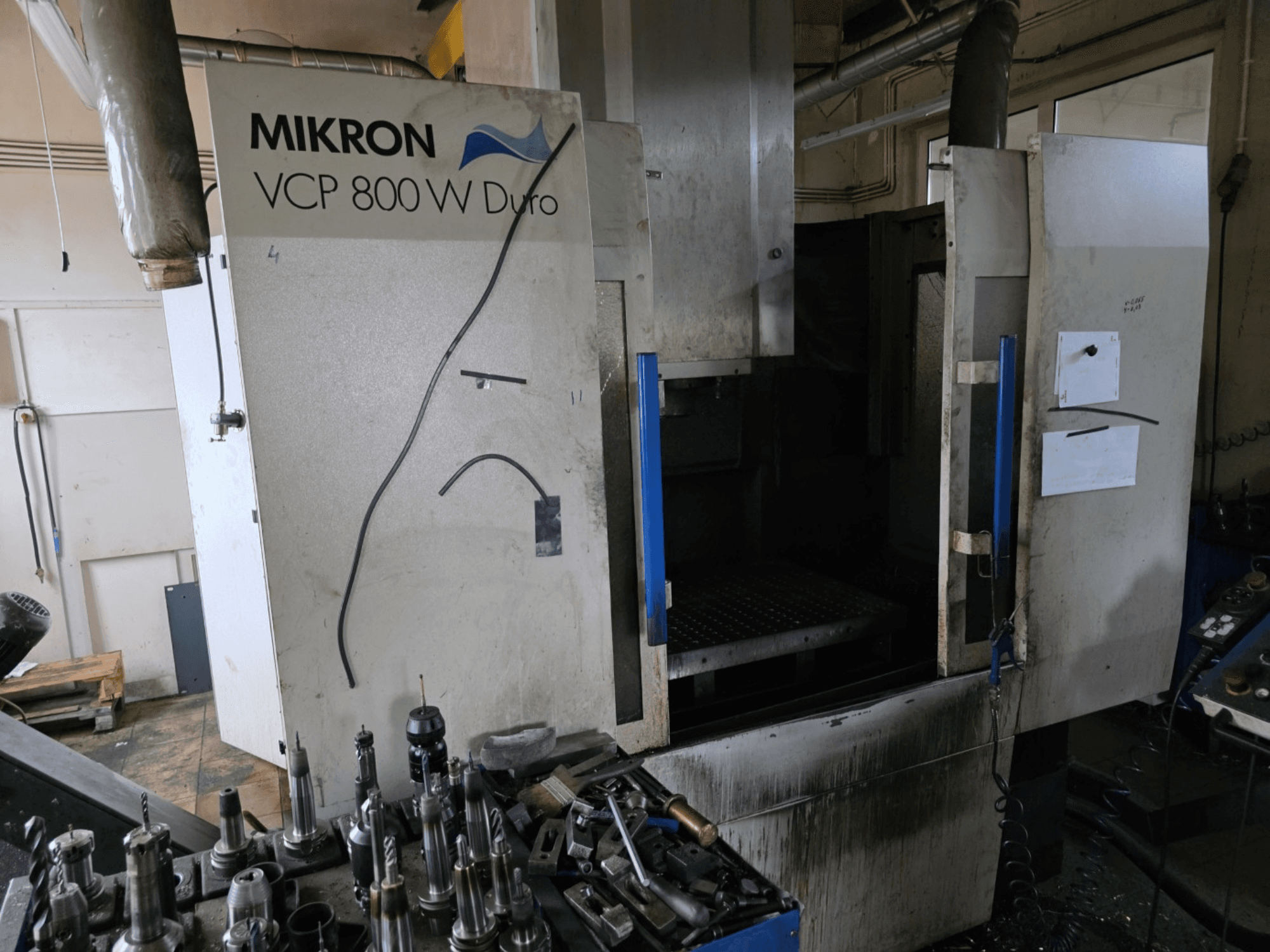 Mikron VCP 800 W Duro -jyrsinkone sivukuvassa, työkalut ja hallintalaitteet näkyvät etualalla.