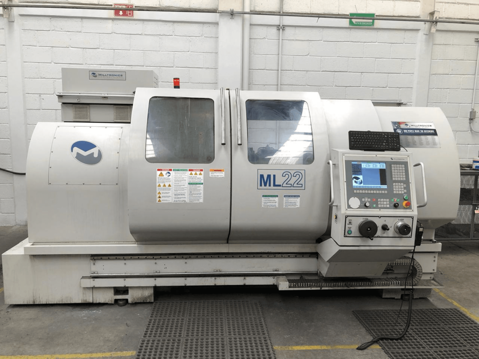 Pystytyöstökeskus MILLTRONICS RH 20, etukuva, jossa näkyy ohjauspaneeli, tuotemerkin logo ja koneen turvatarrat.