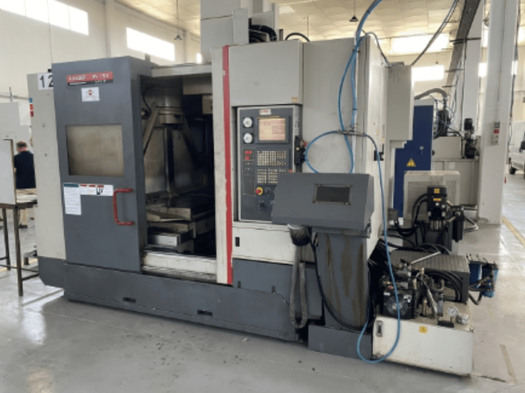 Quaser MV154APC-912 -pystytyöstökeskus, etukuva, jossa näkyy ohjauspaneeli, avoin ovi ja koneen osat.