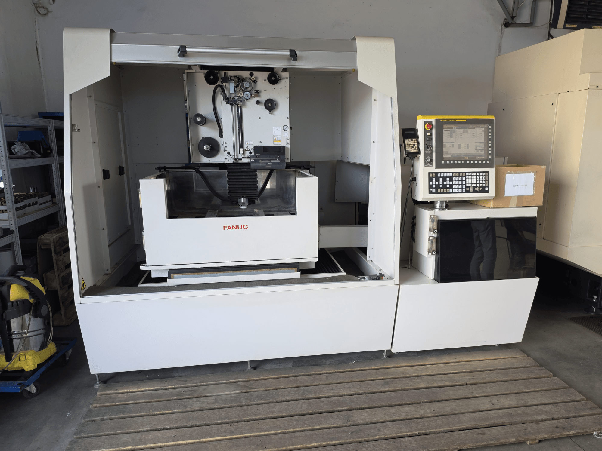 FANUC ROBOCUT alpha-1iD -lanka-EDM-kone, etunäkymä, jossa näkyvät ohjauspaneeli, työtila ja kompakti rakenne työpajaympäristössä.