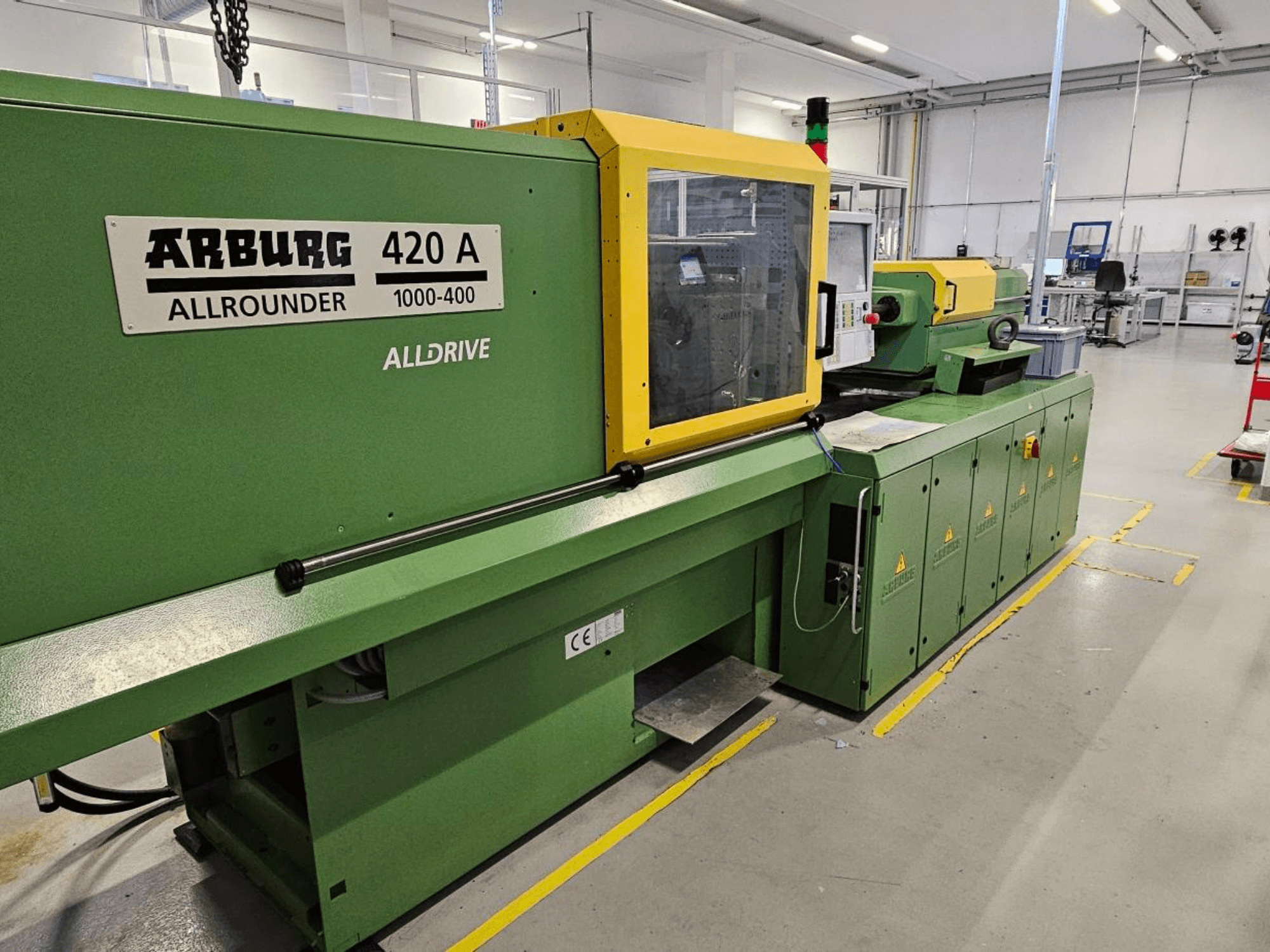 ARBURG 420 A Allrounder 1000-400, etukuva; vihreä kone, jossa on keltainen paneeli, kosketusnäyttö ja turvavarusteet.