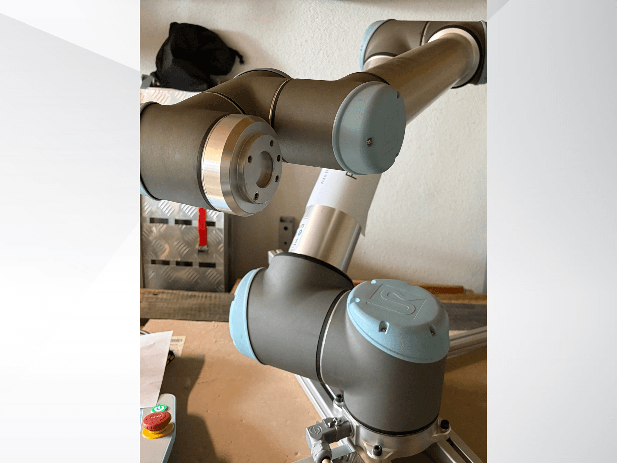 Universal Robots UR10 -robottikäsivarren sivukuva läheltä, jossa näkyvät nivelet ja harmaansiniset muotoiluelementit.