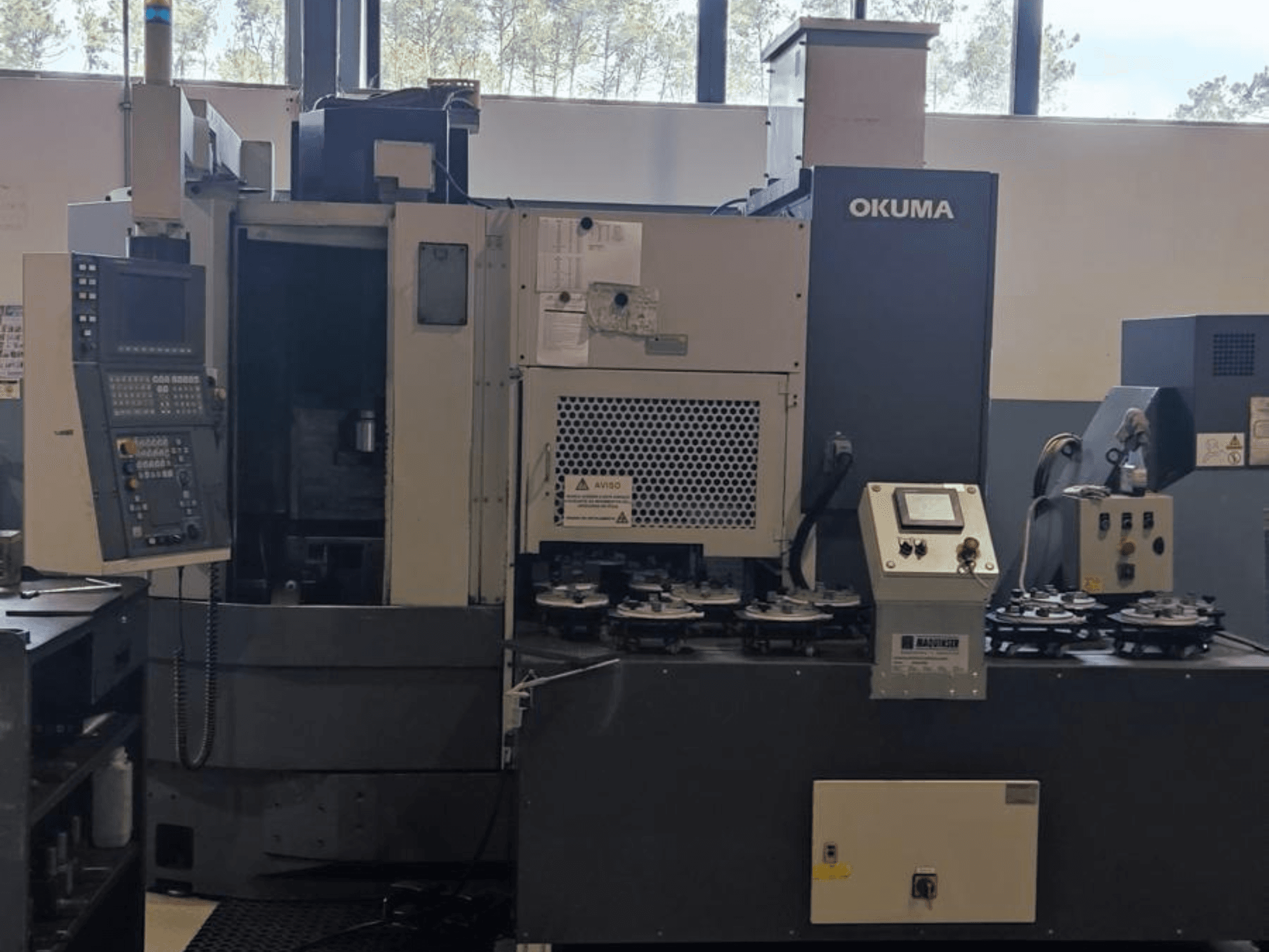 Okuma LVT300 -pystysorvauskone etukuvassa, jossa on ohjauspaneeli, työkalunpitimet ja työstöalue.