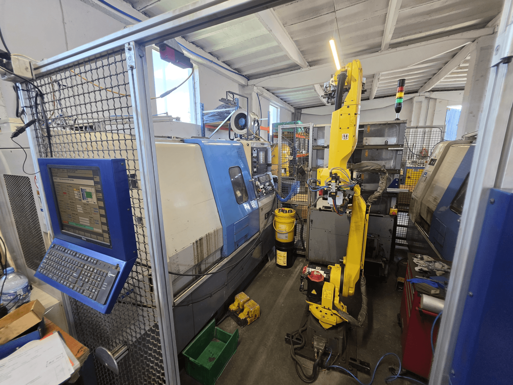 Hyundai HIT-200C -vaakakääntötyöstökone, jossa on FANUC M-20iA -robotti; etunäkymä, jossa näkyvät ohjauspaneeli ja koneen kokoonpano.