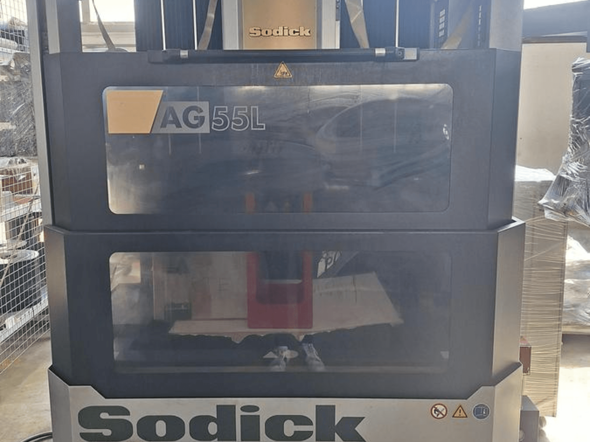 Sodick AG 55L Die-Sinking EDM -kone, etukuva, jossa hallintalaitteet näkyvät läpinäkyvien paneelien läpi, ja työtila sisällä.