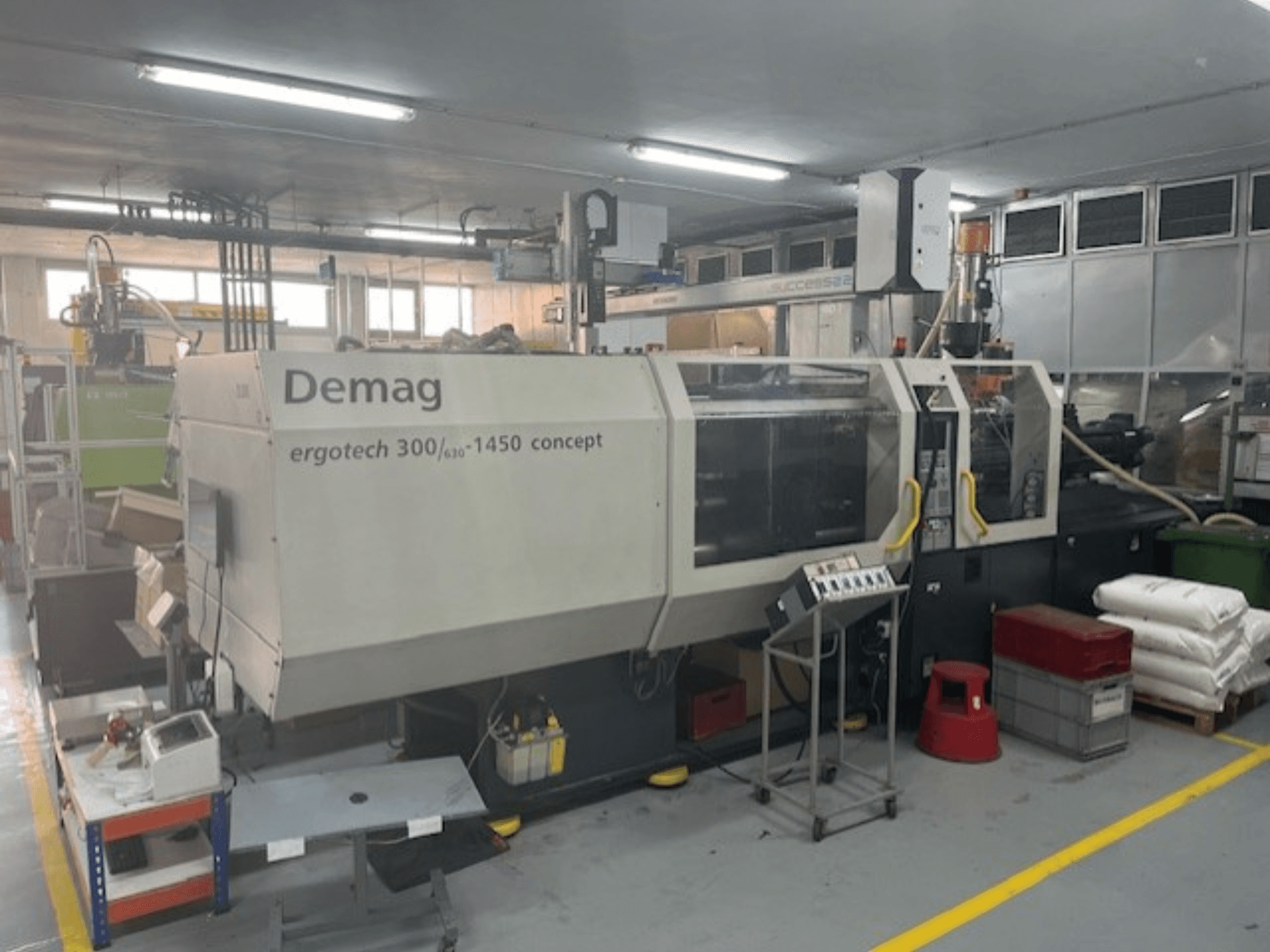 Demag ERGOTECH CONCEPT 3000-1450 hydraulinen ruiskuvalukone, etukuva, jossa on hallintalaitteet ja materiaalit lähellä.
