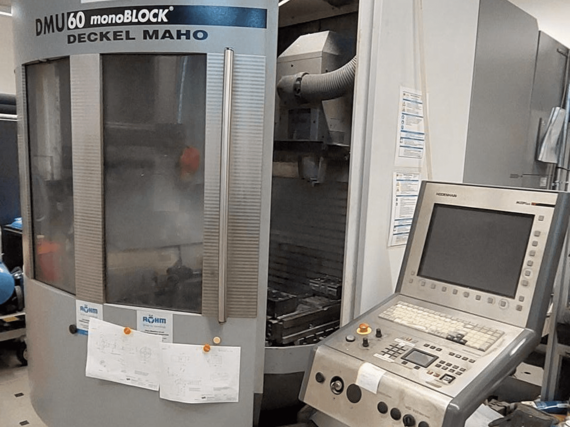 DMU 60 monoBLOCK by Deckel Maho, CNC-jyrsinkoneen etukuva, johon on liitetty ohjauspaneeli ja tekniset piirustukset.