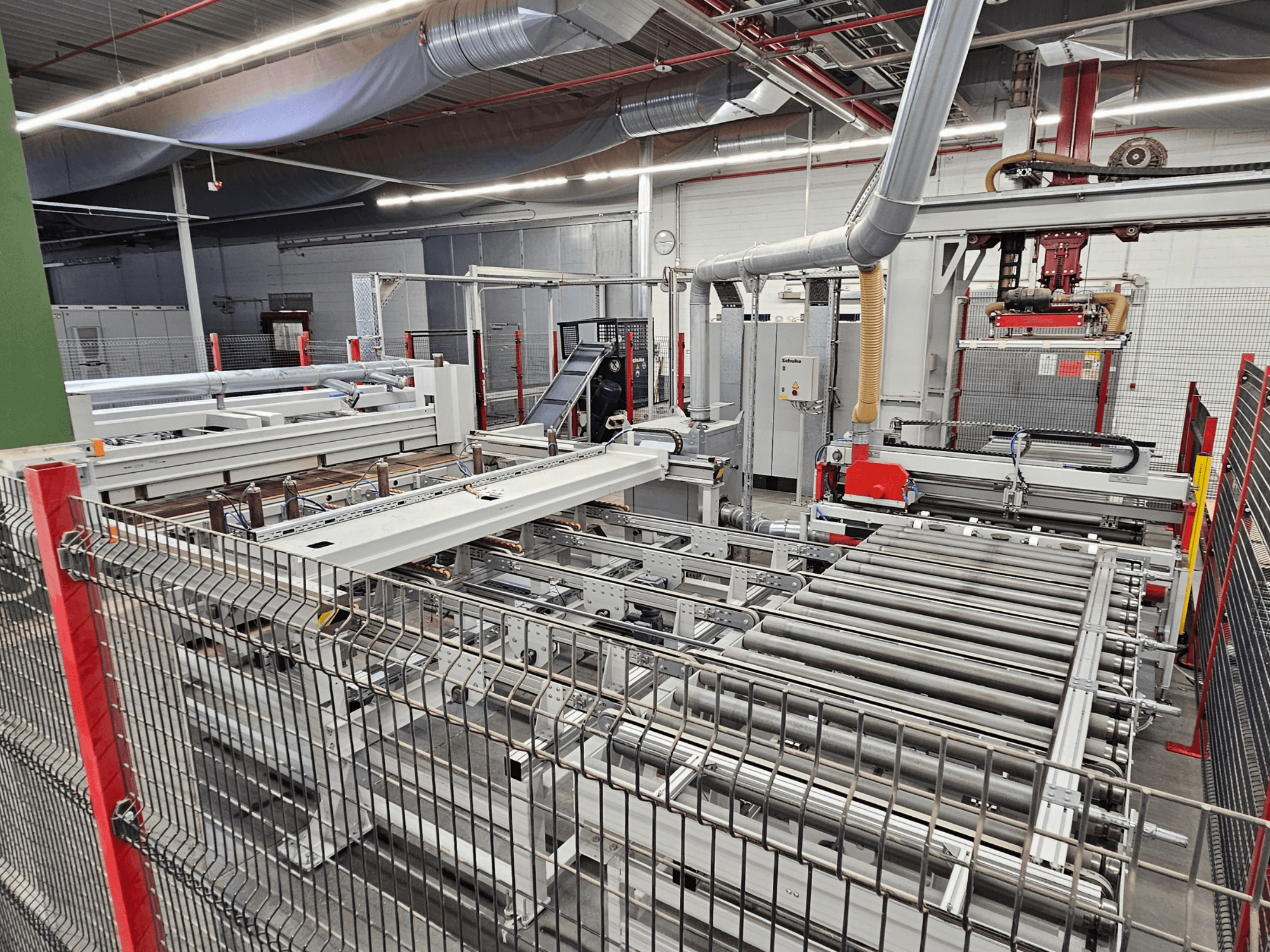 HOLZMA HPP81-3200 -levysaha etukuvassa, jossa on kuljetinrullia ja koneenosia työpajassa.