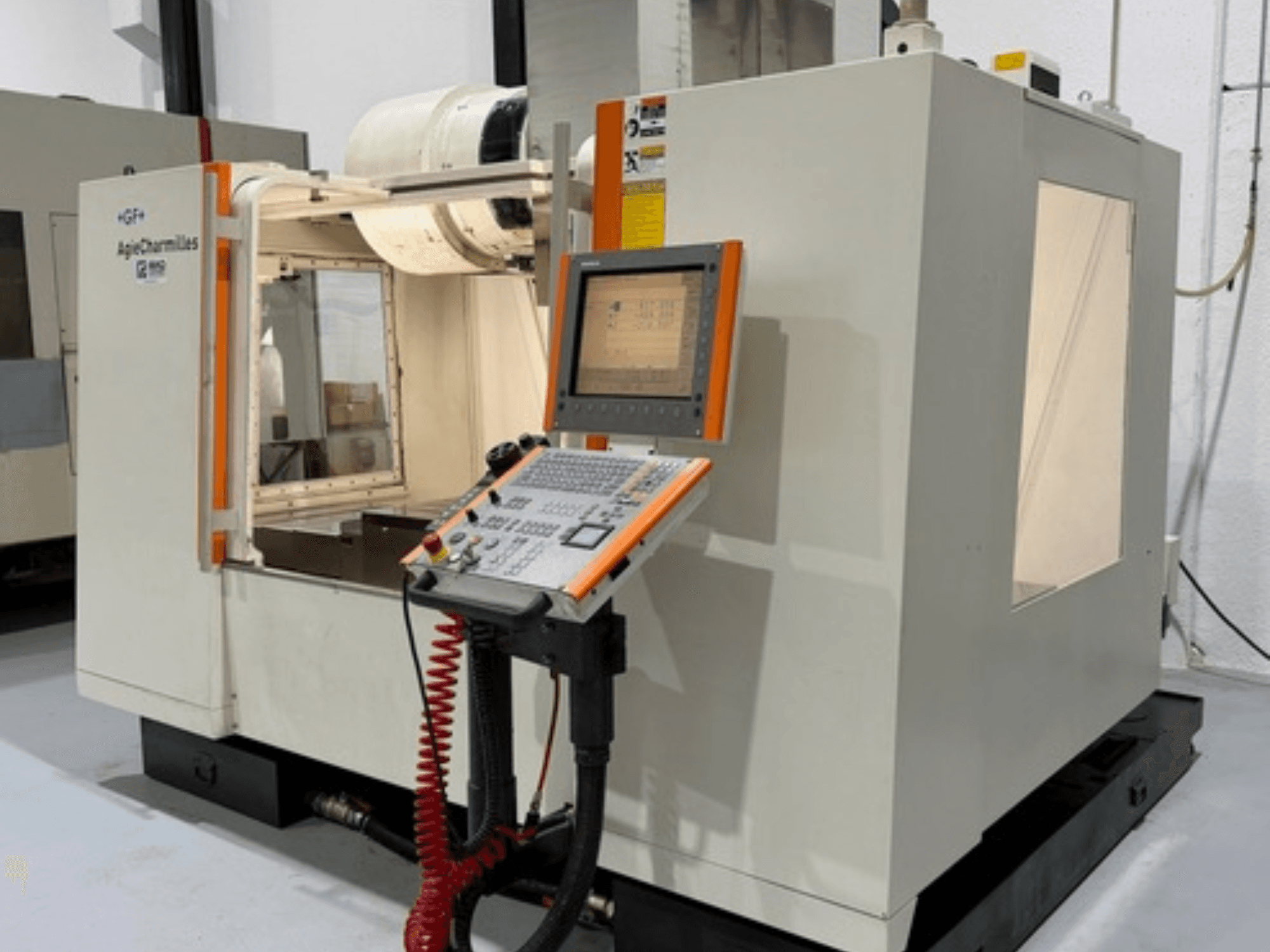 GF AgieCharmilles MIKRON -jyrsinkone sivukuvassa, jossa on ohjauspaneeli, jossa on painikkeet ja näyttö.