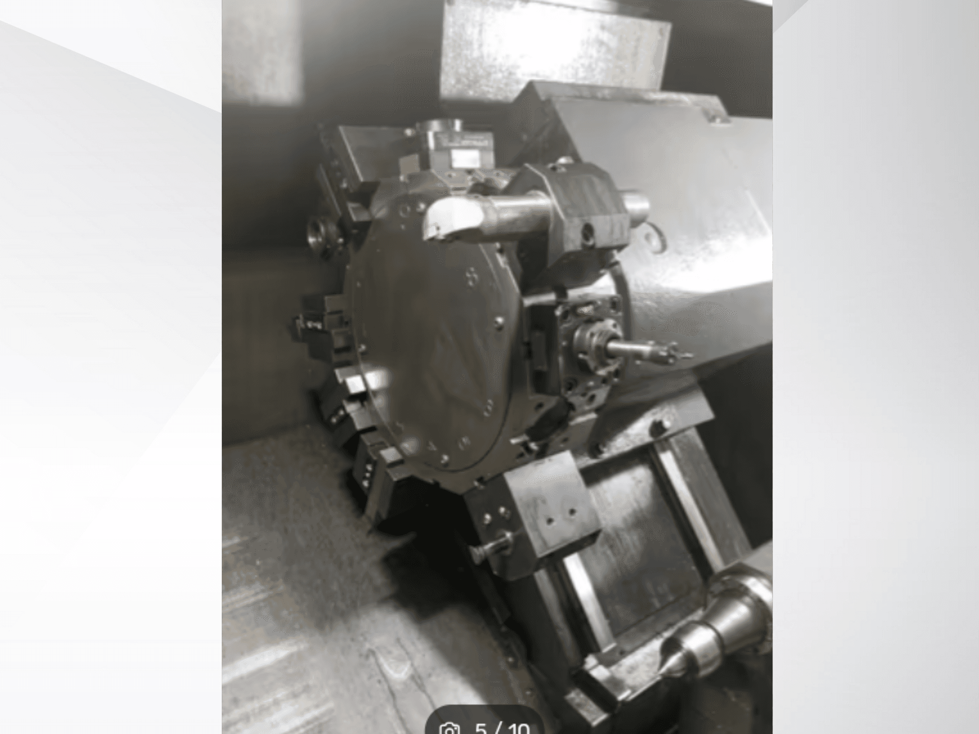 Lähikuva tarkkuuskonekappaleesta, jossa näkyy hammaspyöriä ja metalliosia, kuvattuna kulmasta. Merkkiä ei näy.