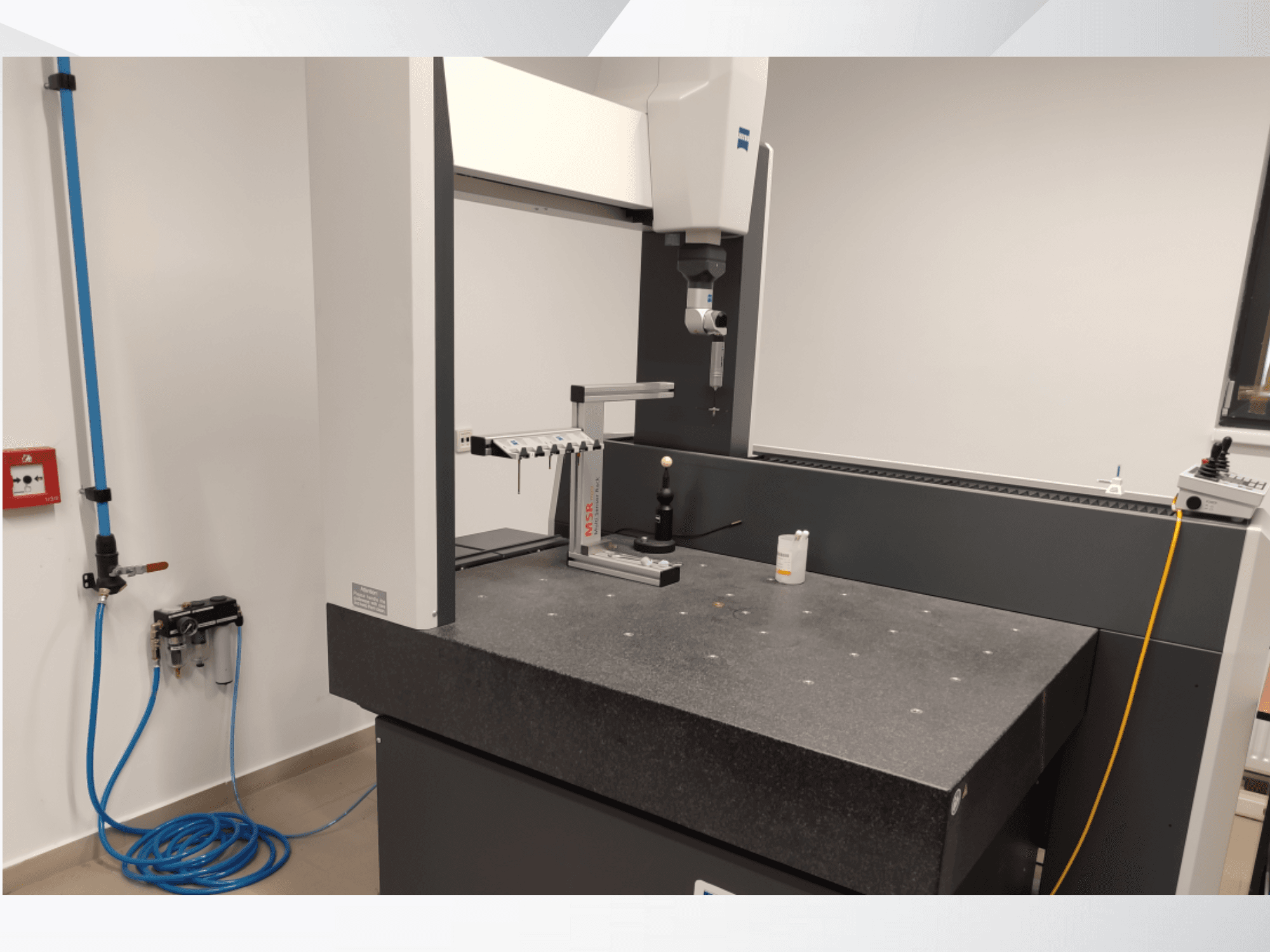 MSR-mittauslaite laboratoriossa, etunäkymä, jossa näkyy graniittipöytä, kalibrointipallo ja liitetyt apulaitteet.