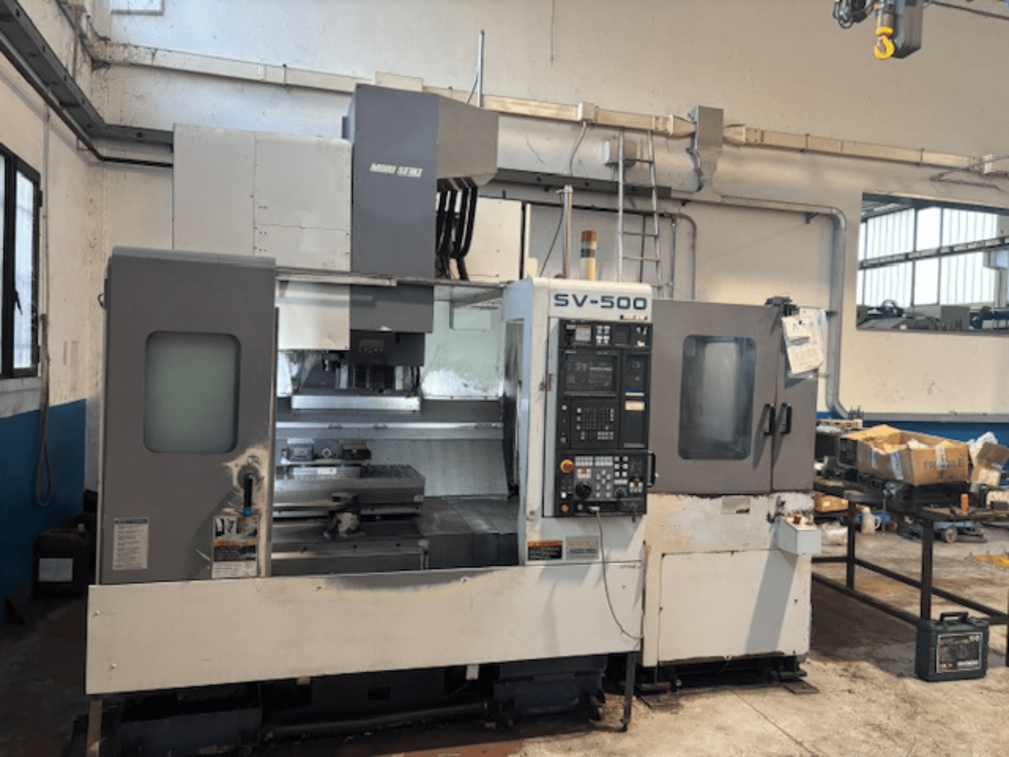 MORI SEIKI SV-500/40 -pystytyöstökeskus työpajassa, etukuva ohjauspaneelista ja työstöalueesta.