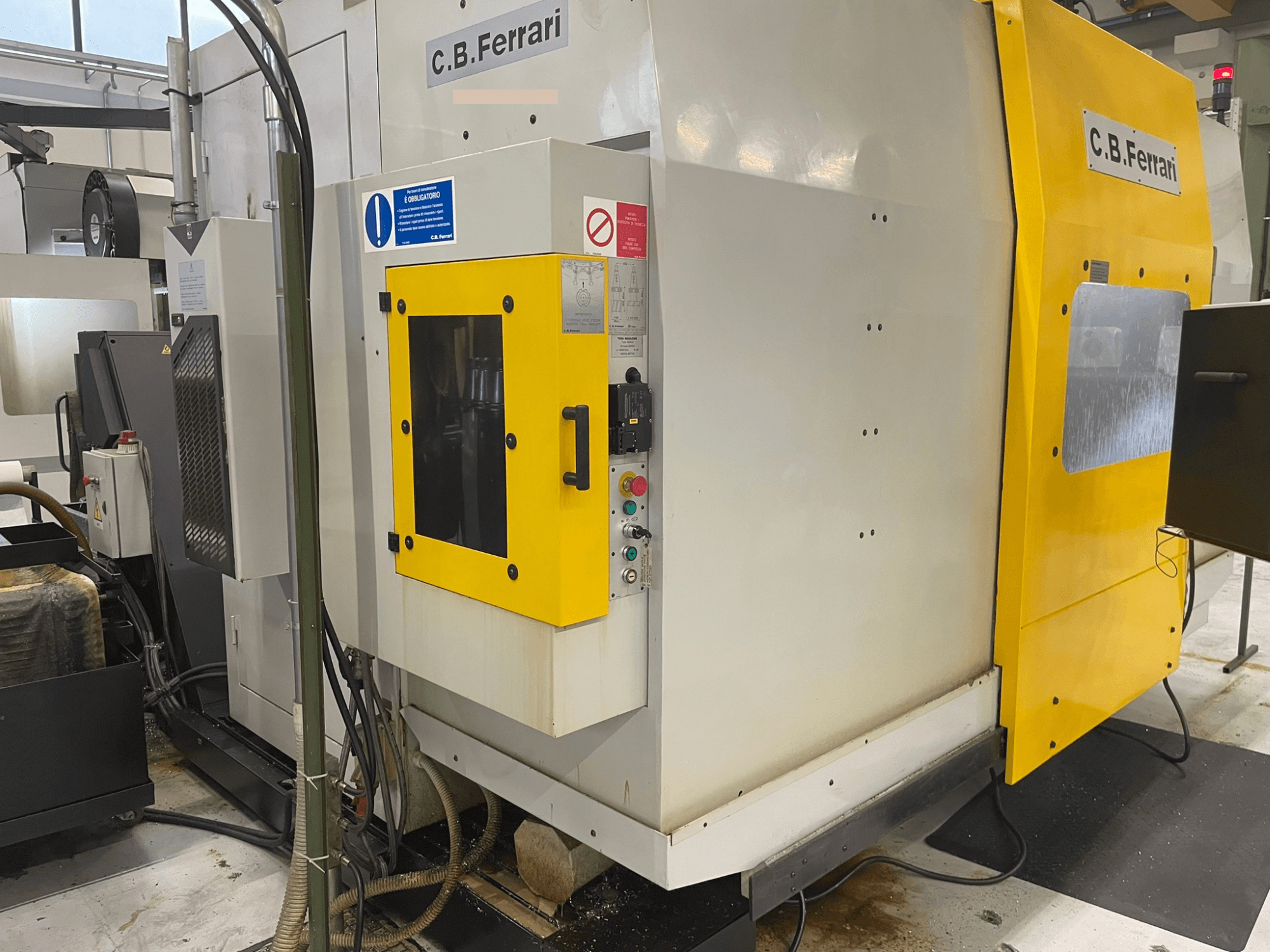 C.B. Ferrari -teollisuuskone, etukuva; keltainen ovi, ohjauspaneeli ja näkyvät työstökomponentit.