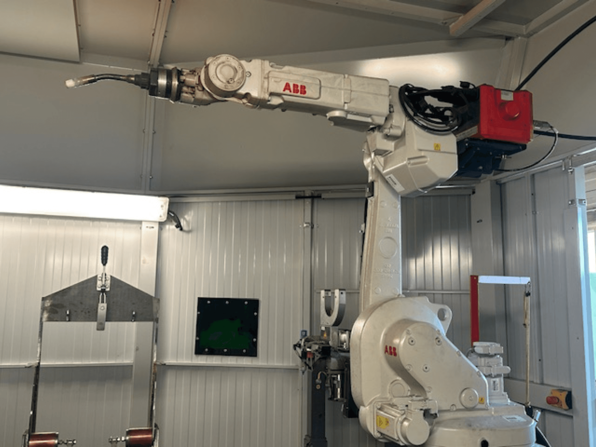 ABB Schweißroboter Flex Arc - sivukuva robottikäsivarresta hitsaustyökalun kanssa, jossa näkyy yksityiskohtia, kuten ohjauspaneeli ja kaapelit.