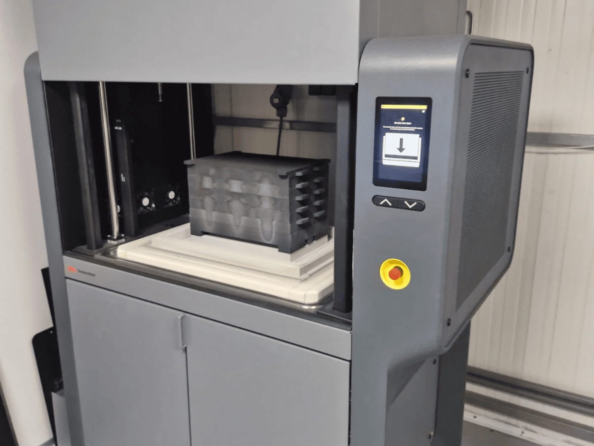 Metal Studio 2 3D-tulostin Desktop Metalilta, etunäkymä, jossa näkyy ohjauspaneeli ja tulostuspeti mustalla säiliöllä.