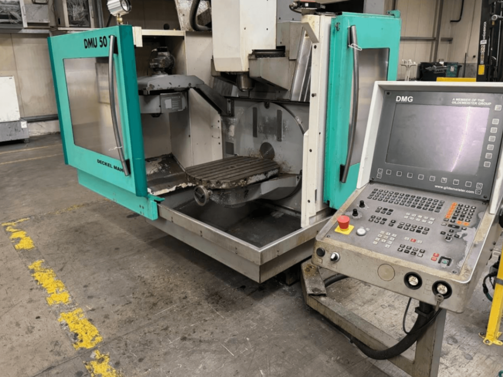 DMG DMU 50 -jyrsinkone, jossa on avoimet ovet ja jossa näkyy sisätilat ja ohjauspaneeli edestä katsottuna.