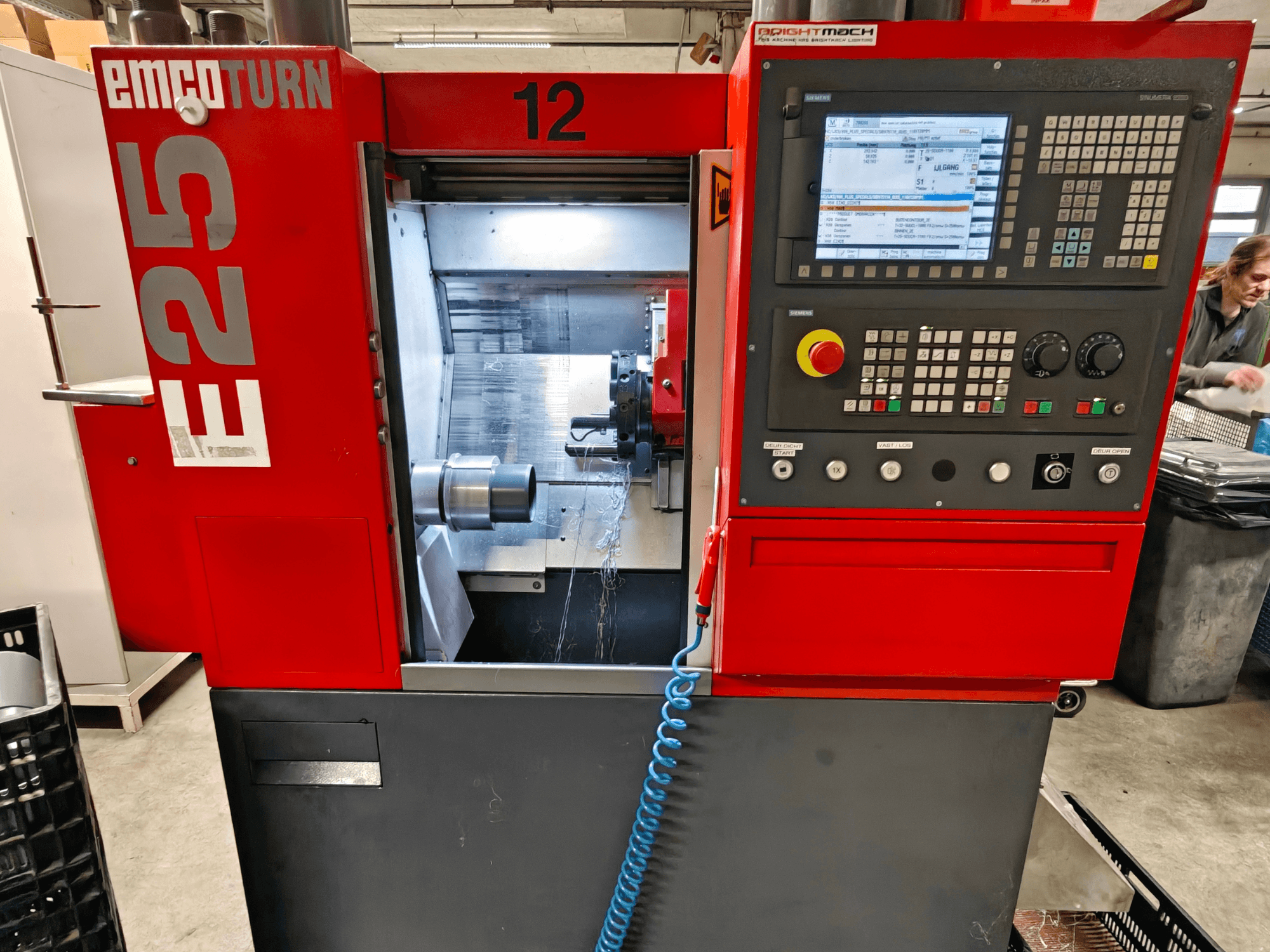 EMCO TURN E25 -koneen etukuva, jossa on ohjauspaneeli, työkalunpidin ja sisätila, jossa leikkuutyökalu näkyvissä.