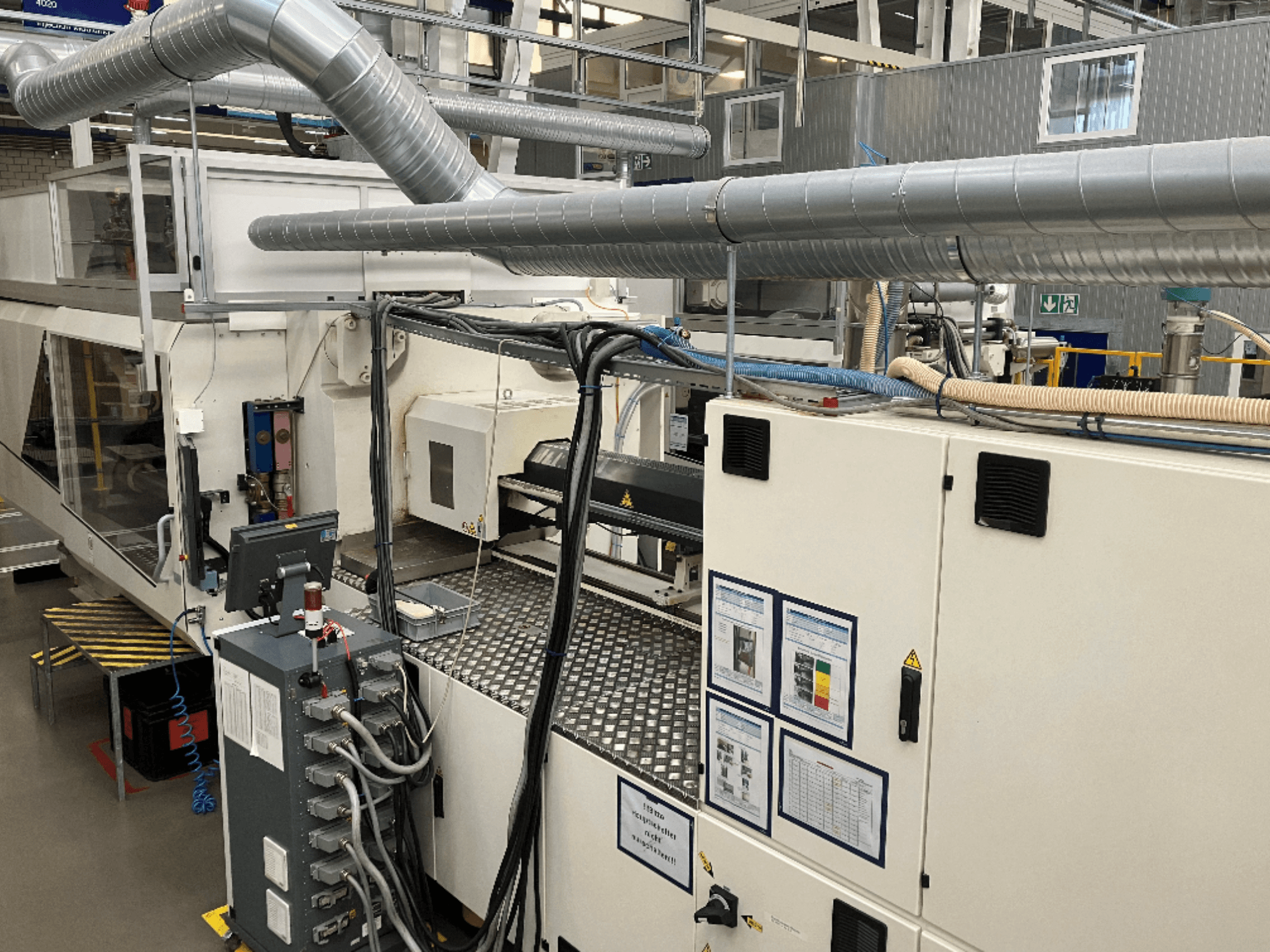 Teollisuuskoneet, joissa on laajat putkistot, ohjauspaneeli ja käyttöohjeet ylhäältä alaspäin katsottuna.