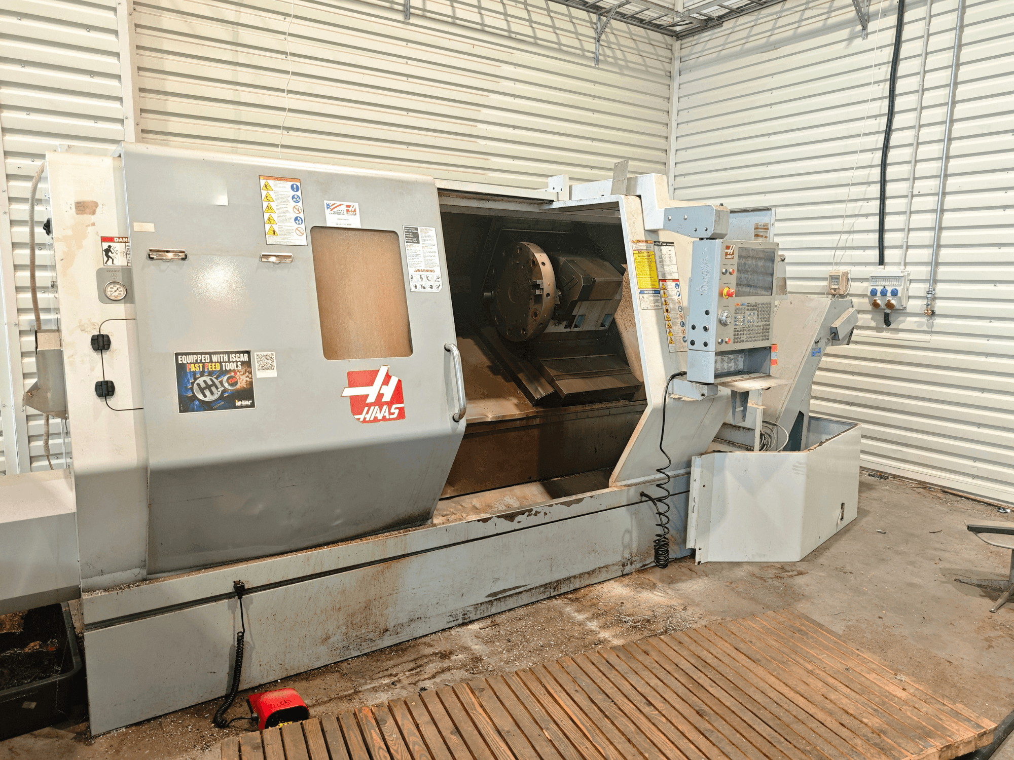 Haas SL-40HE -vaakasuora sorvi, etunäkymä, jossa näkyvät ohjauspaneeli, työtila ja turvallisuusmerkinnät.