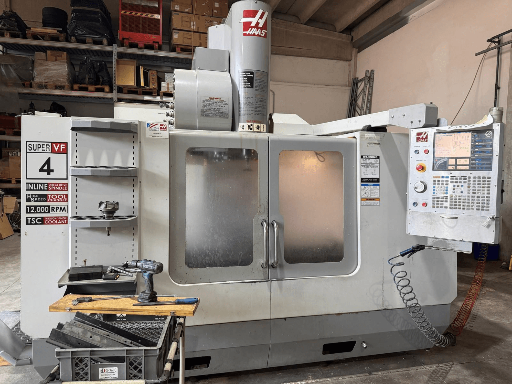 HAAS VF-4SSHE -pystykoneistuskeskukseen edestä katsottuna: ohjauspaneeli, työkaluteline ja 12 000 RPM:n kar; nopea ja tarkka kone.