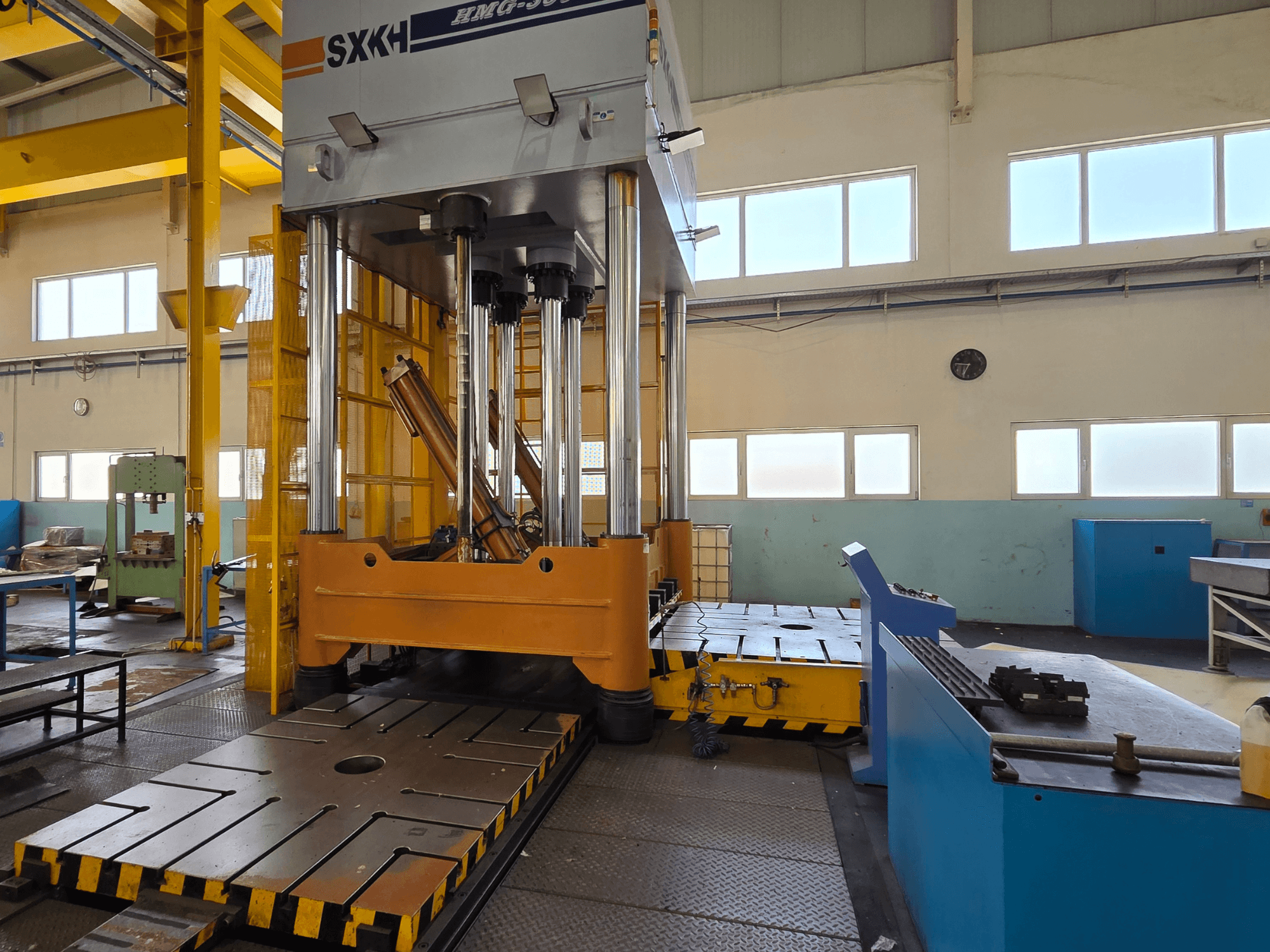 Hydraulinen puristin SXKH HMG-300JM etukuvassa, jossa on suuret puristussylinterit ja vankka alusta tehdasympäristössä.