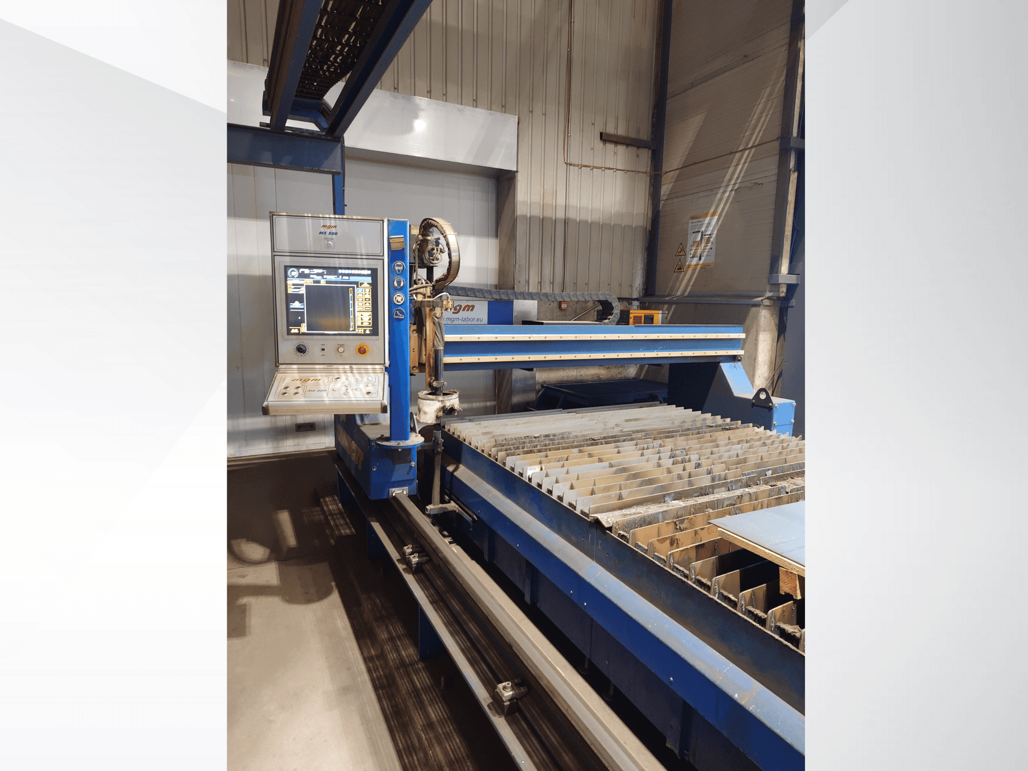 PlasmaCamin CNC-leikkauskone, etukuva, jossa näkyy ohjauspaneeli ja metallileikkaussänky, jossa on säleet.